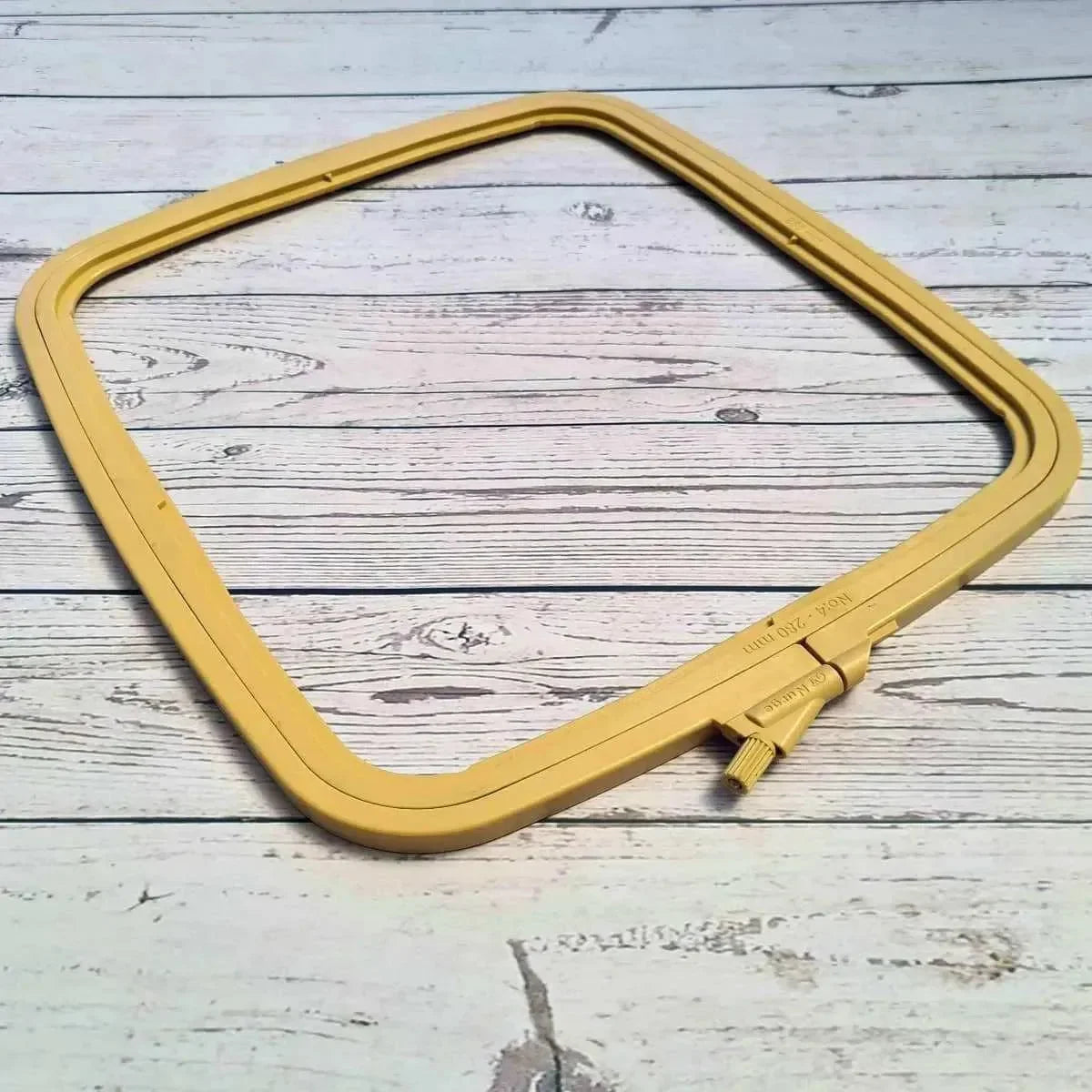 Yellow embroidery hoop on a wooden surface