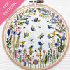 Embroidery hoop with floral and bird design on a white background