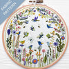 Embroidery hoop with floral and bird pattern on a white background