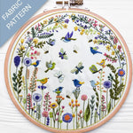 Embroidery hoop with floral and bird pattern on a white background