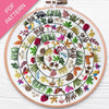 Embroidery hoop with a colorful circular pattern of animals and plants on a white background.
