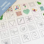 Collection of embroidered patterns on fabric with various designs including birds, flowers, and geometric shapes.