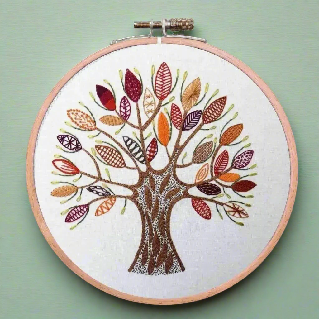 Embroidery hoop with a colorful tree design on a white background