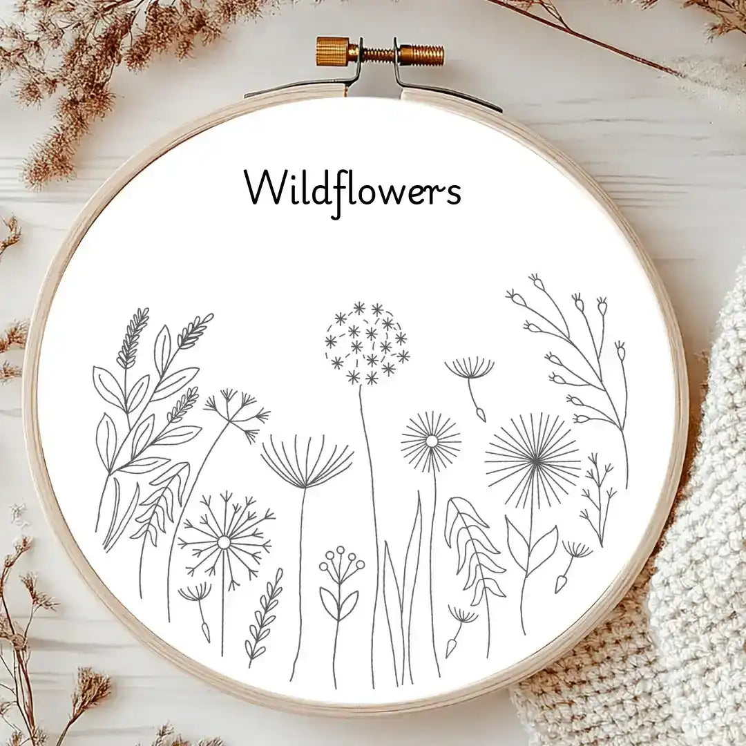 Embroidery hoop with wildflower designs and the word 'Wildflowers' on a wooden surface.