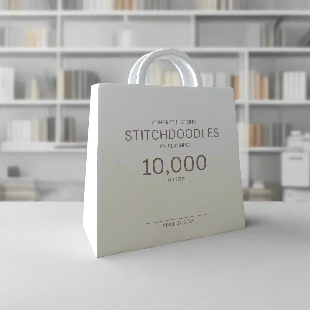 White gift bag celebrating StitchDoodles 10,000 orders milestone, April 21, 2025