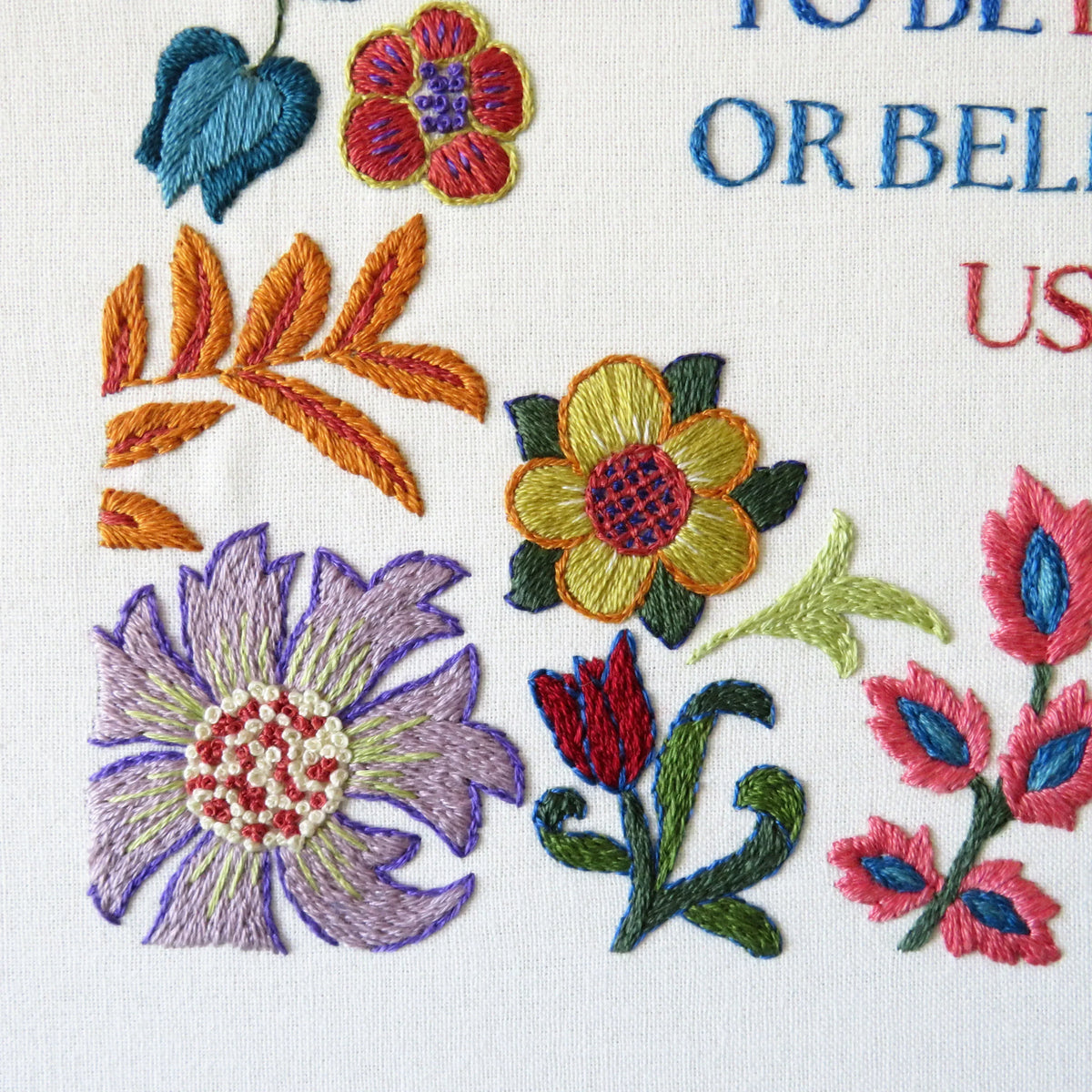 Embroidered floral design with colorful flowers and leaves on a white background.