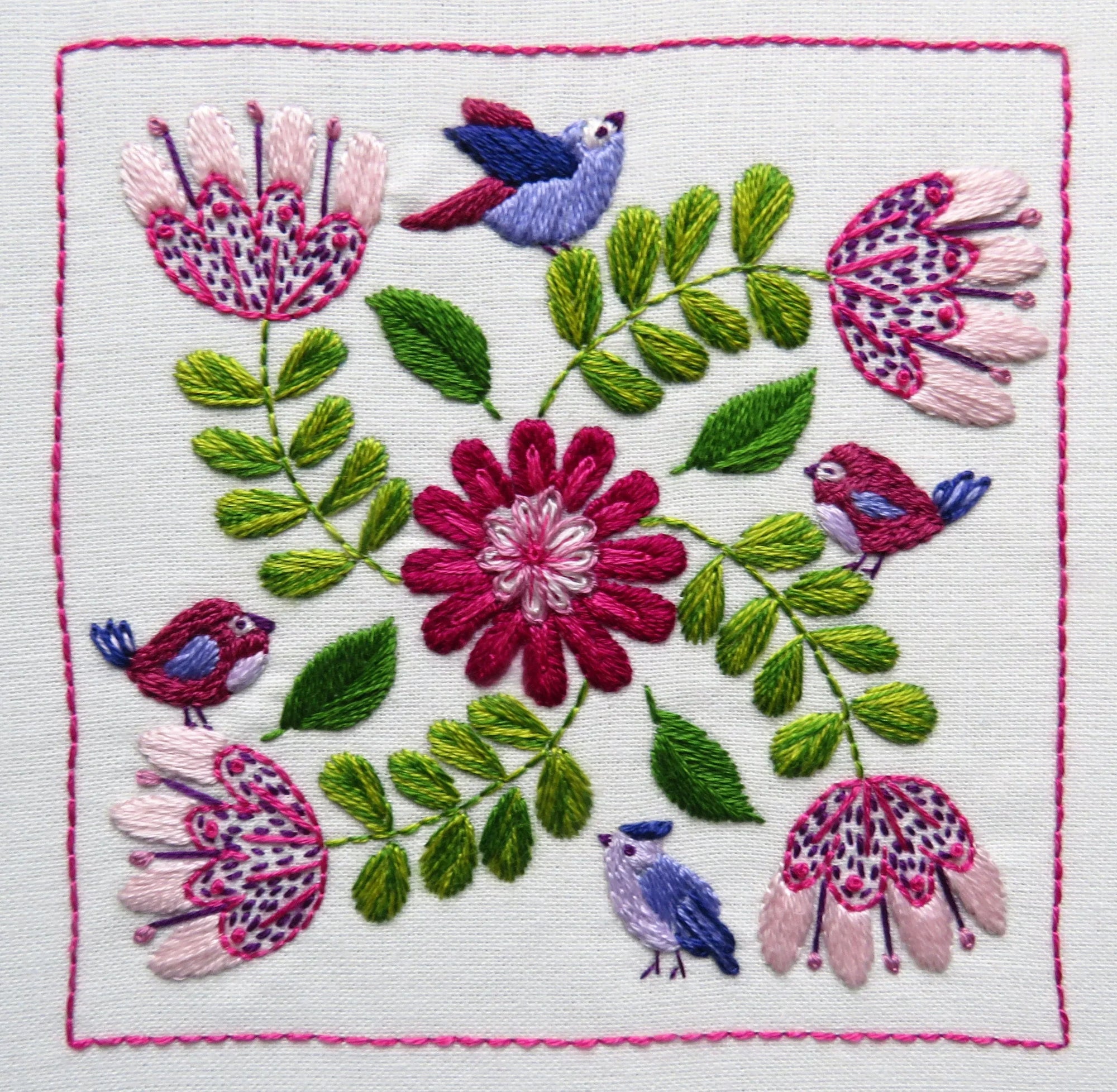 Embroidered design with flowers and birds on a white background