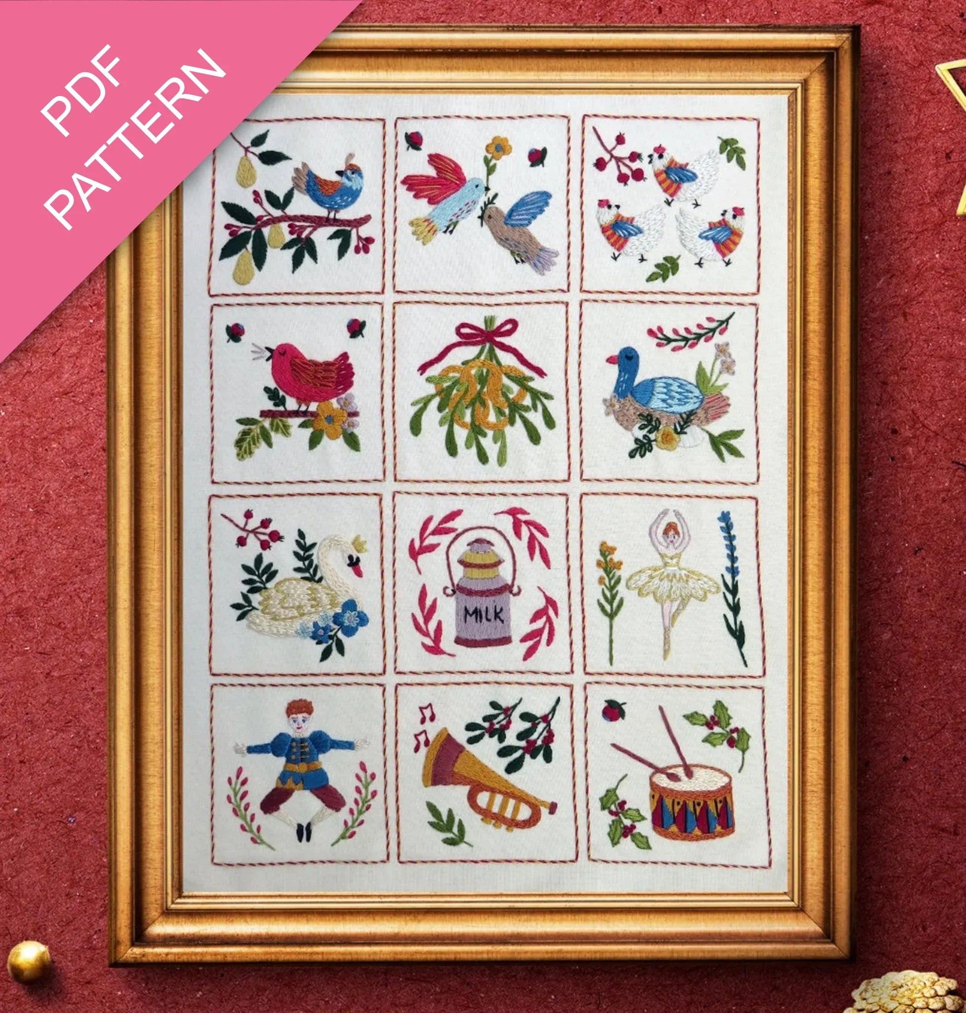 Framed cross-stitched sampler with various designs on a red background