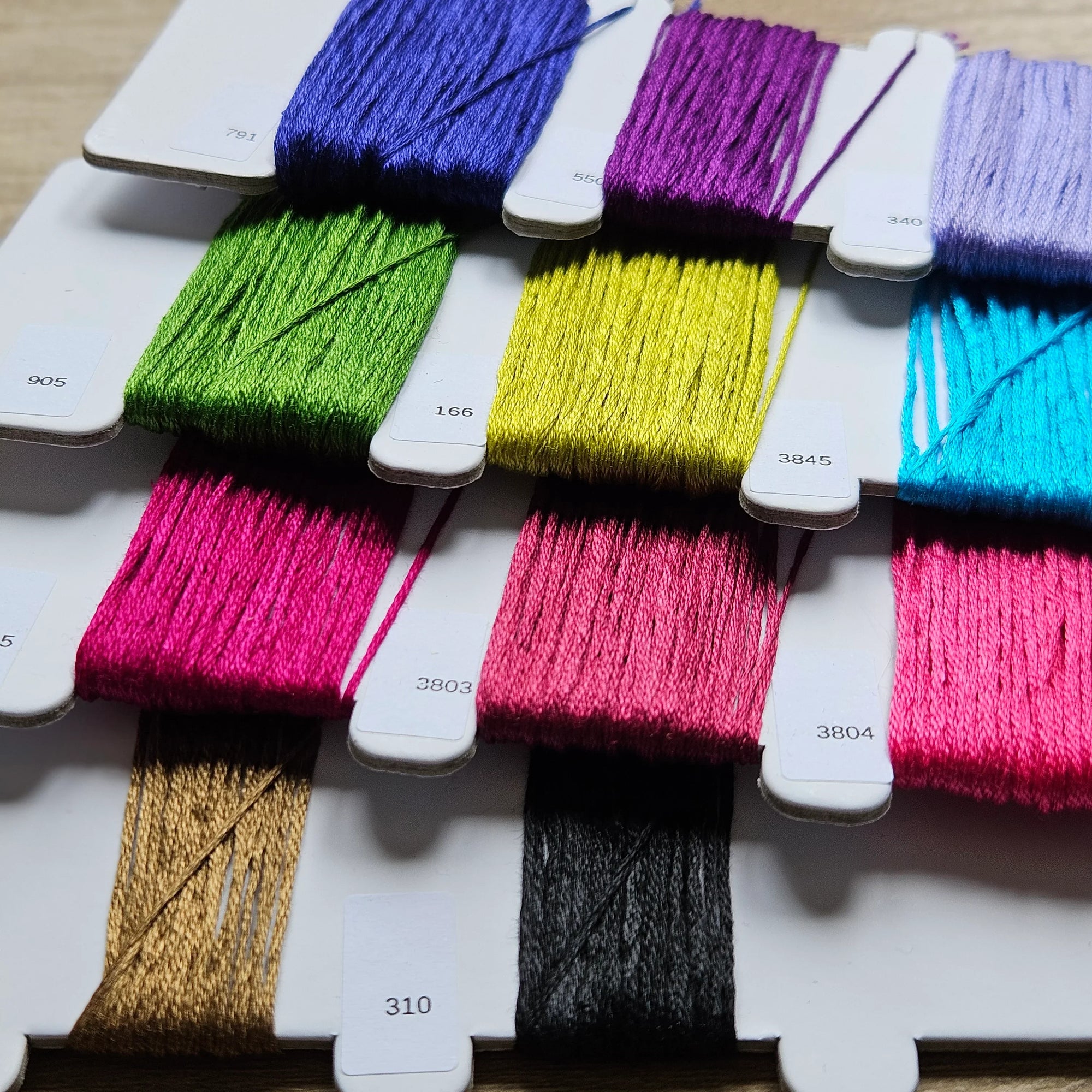 Assorted colorful spools of thread on a white background