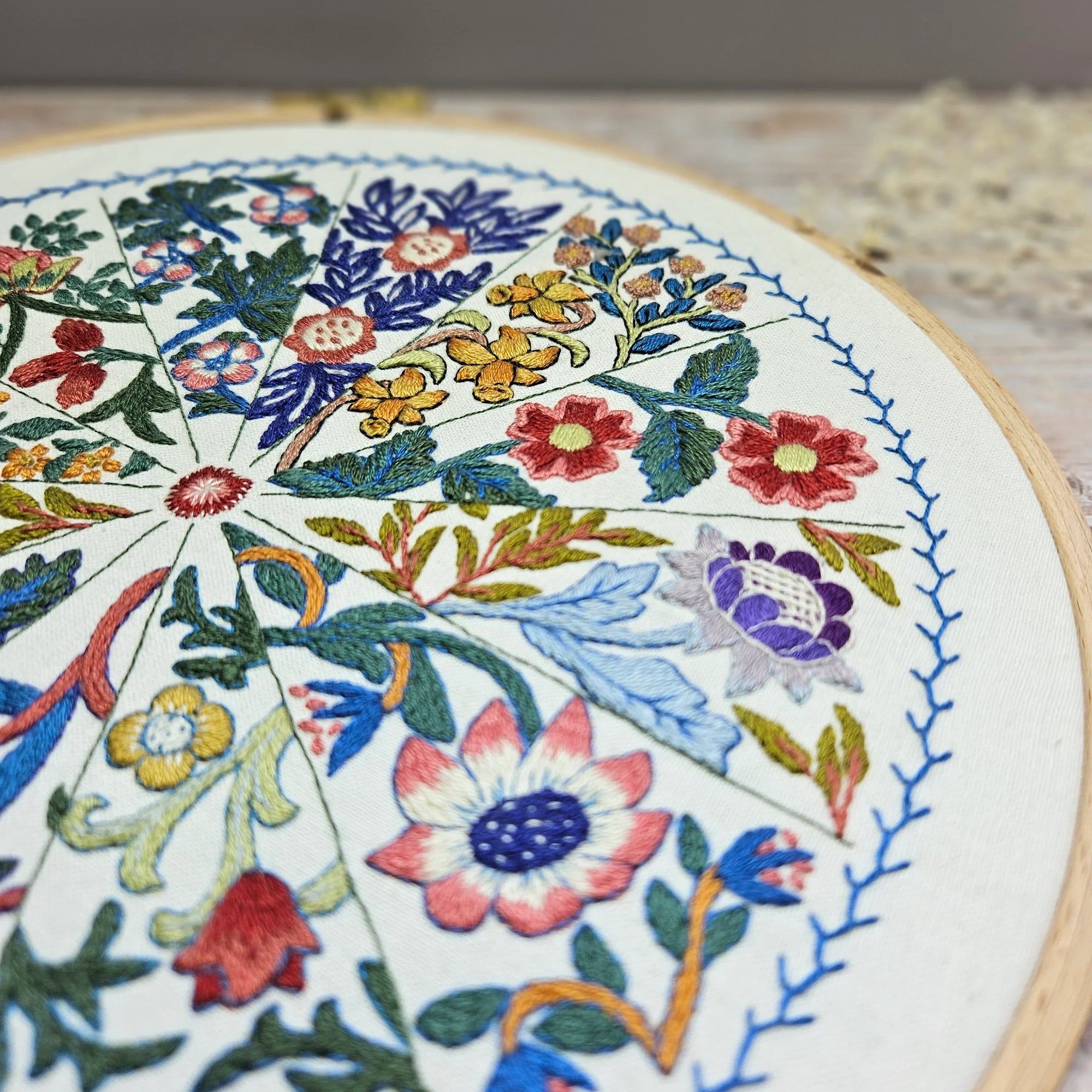 Embroidery hoop with colorful floral embroidery design.