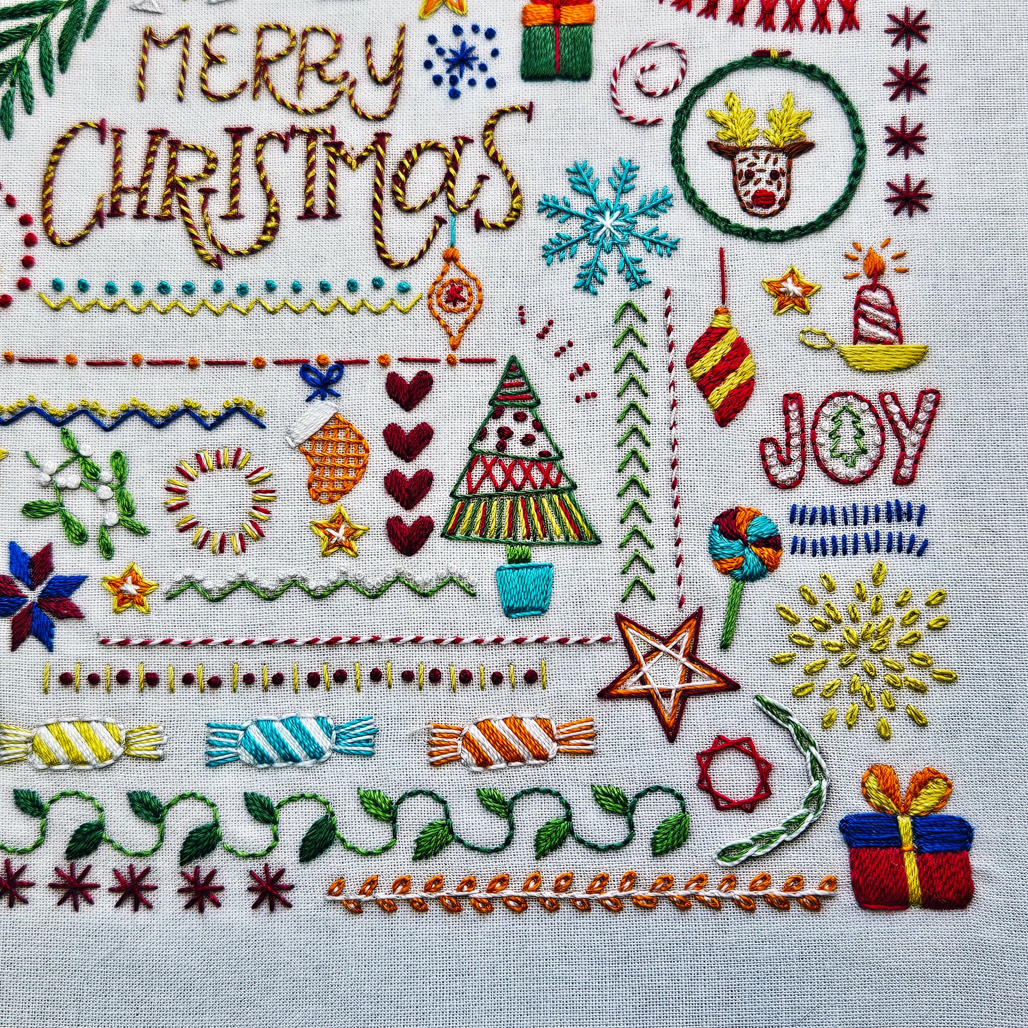 Embroidered Christmas design with text and festive elements on fabric