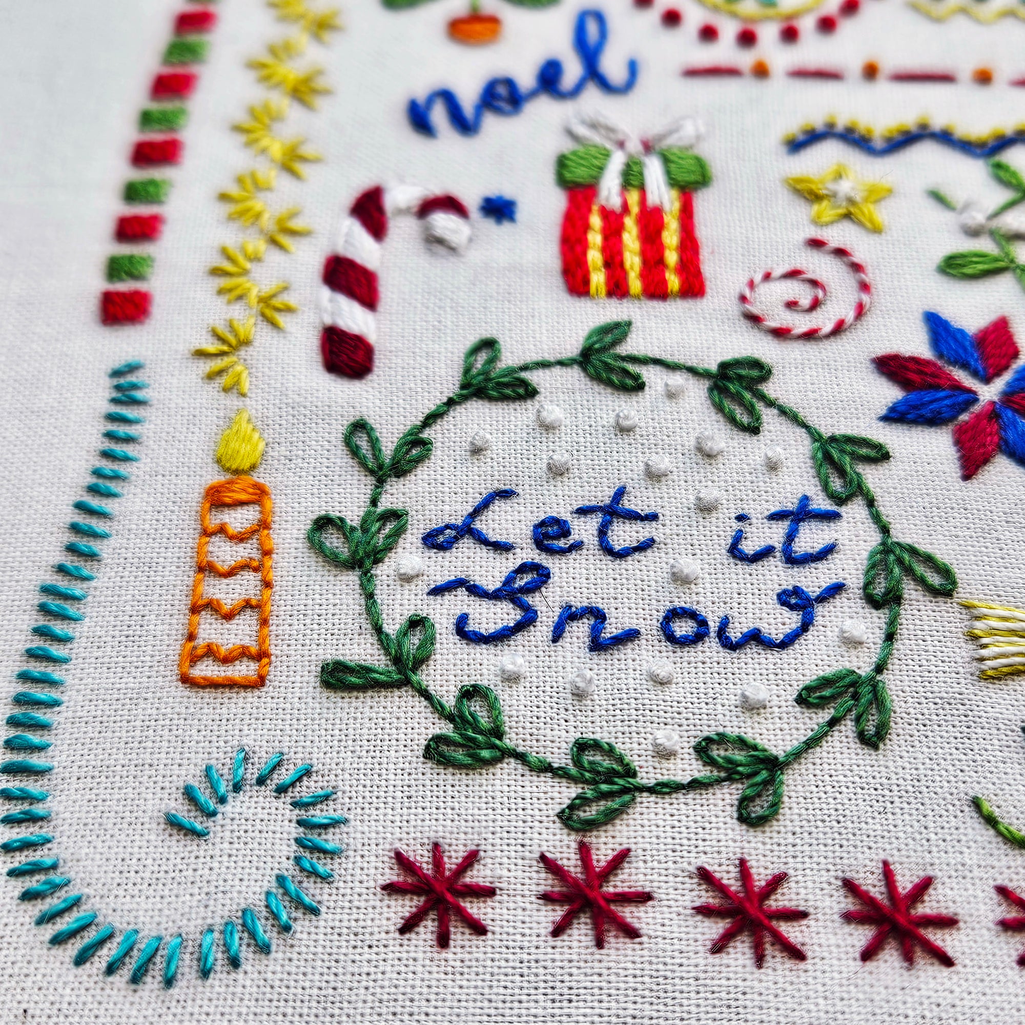 Embroidered Christmas-themed design with 'Let it Snow' text and festive elements.