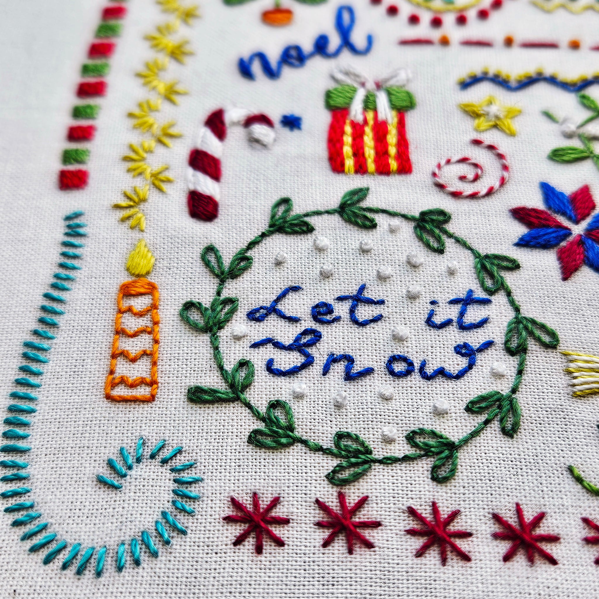 Embroidered Christmas-themed design with 'Let it Snow' text and festive elements.