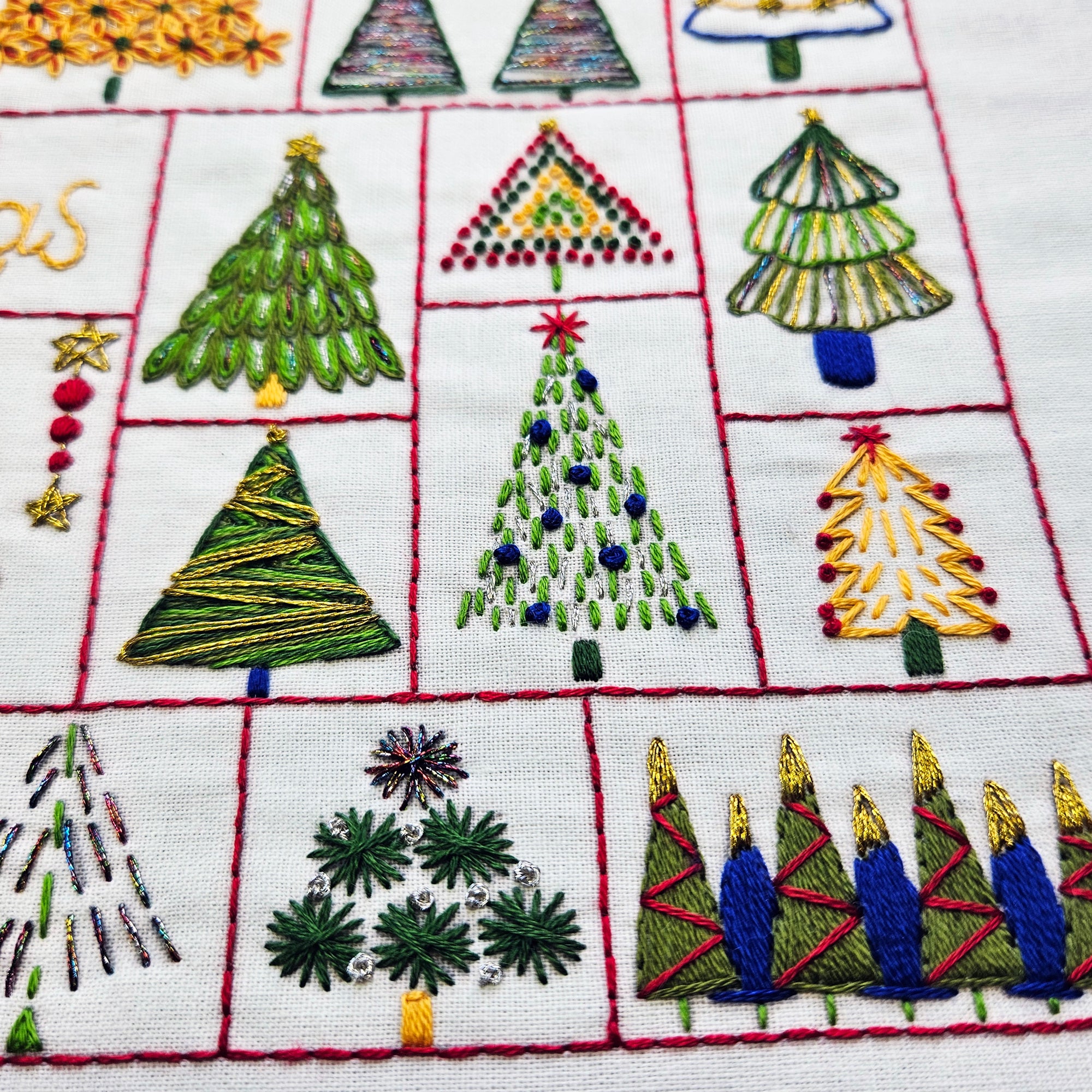 Embroidered Christmas trees on a white fabric background