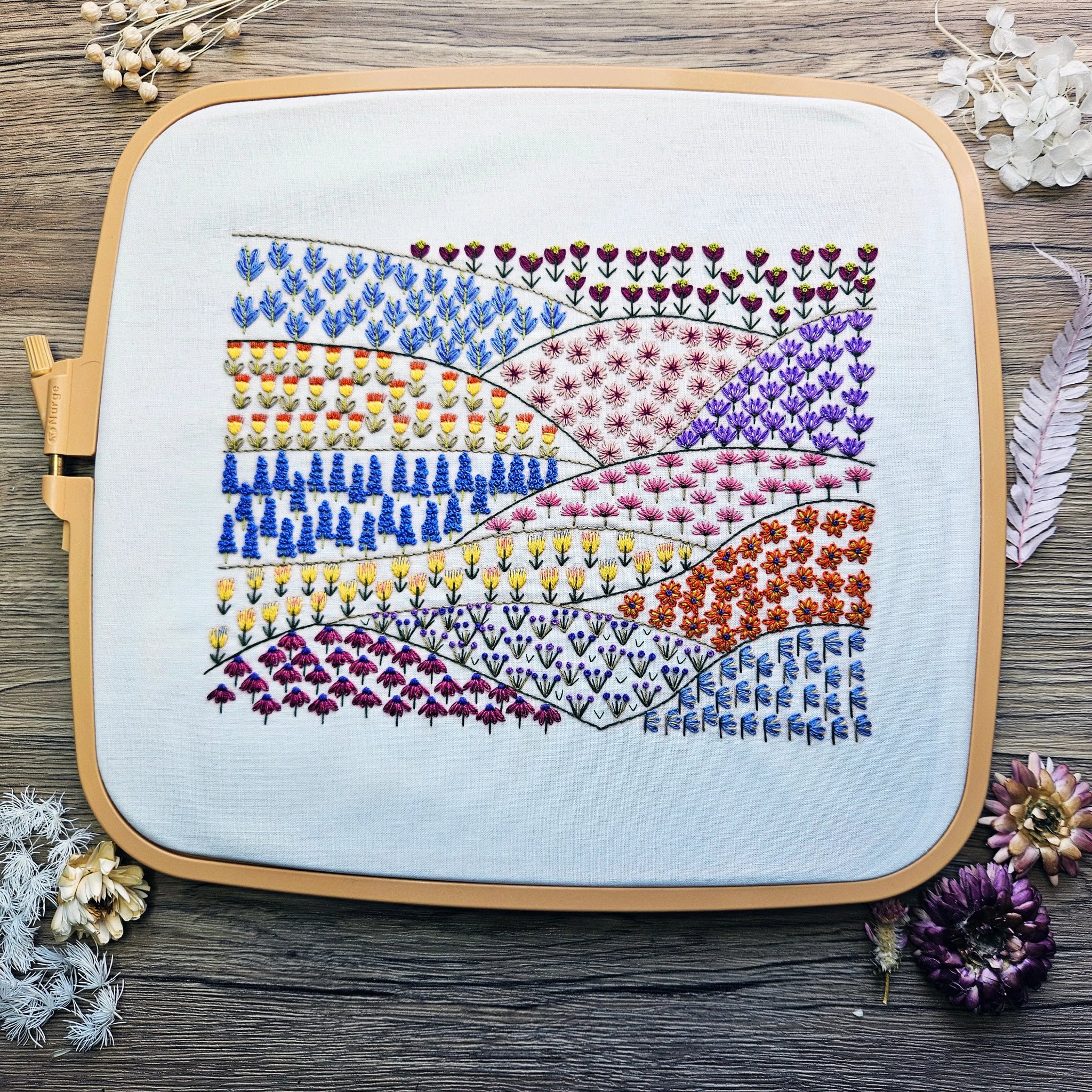 Embroidery hoop with floral pattern on a wooden surface