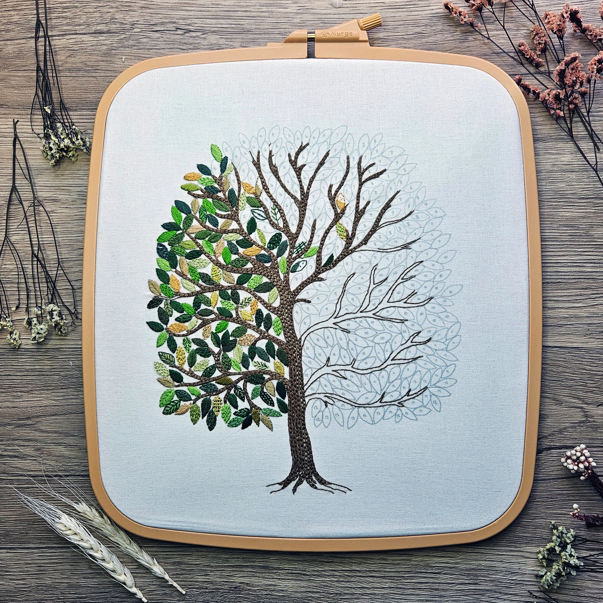 Embroidery hoop with a tree design on a wooden surface