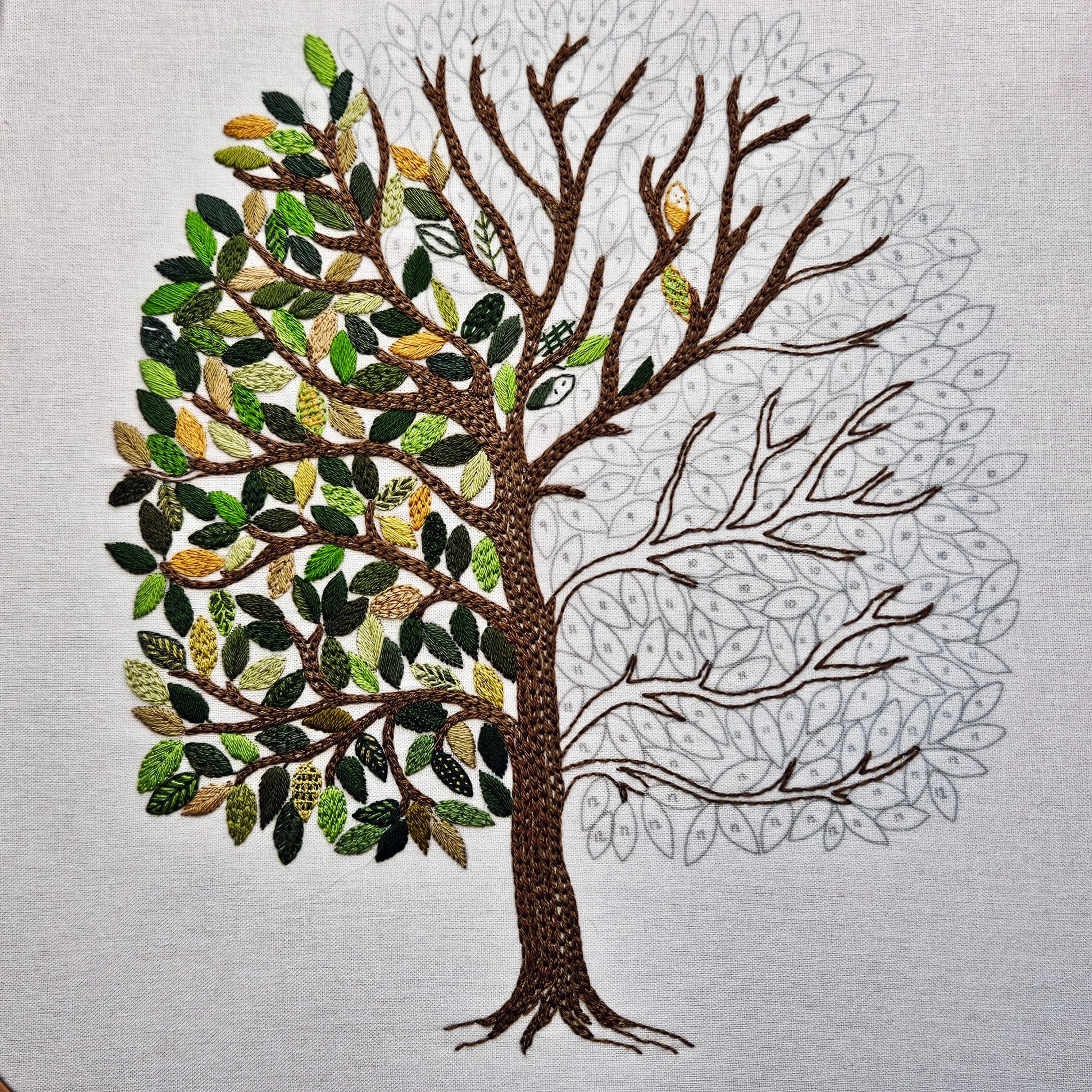 Tree with green leaves and brown branches on a light gray background