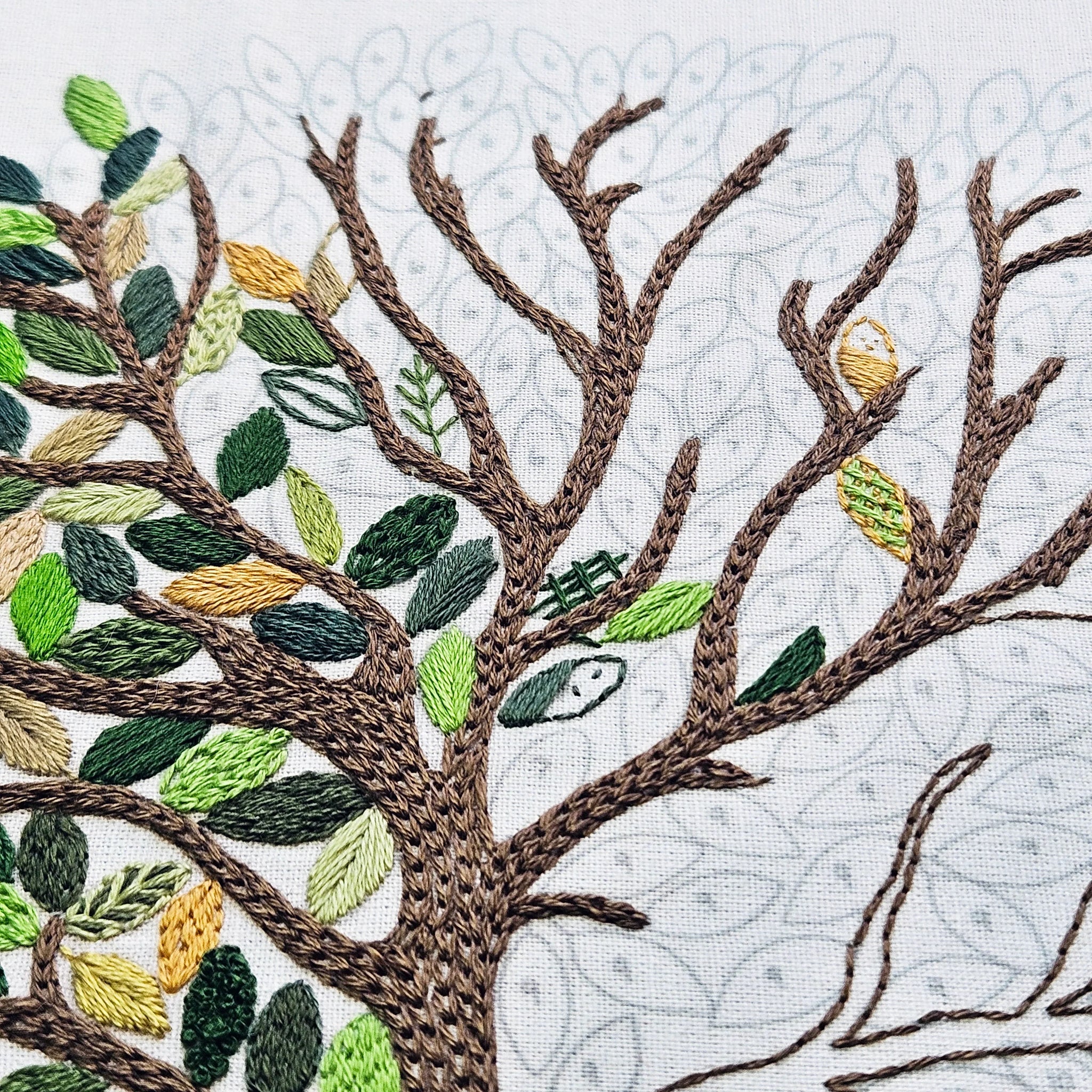 Embroidered tree with leaves on a textured background