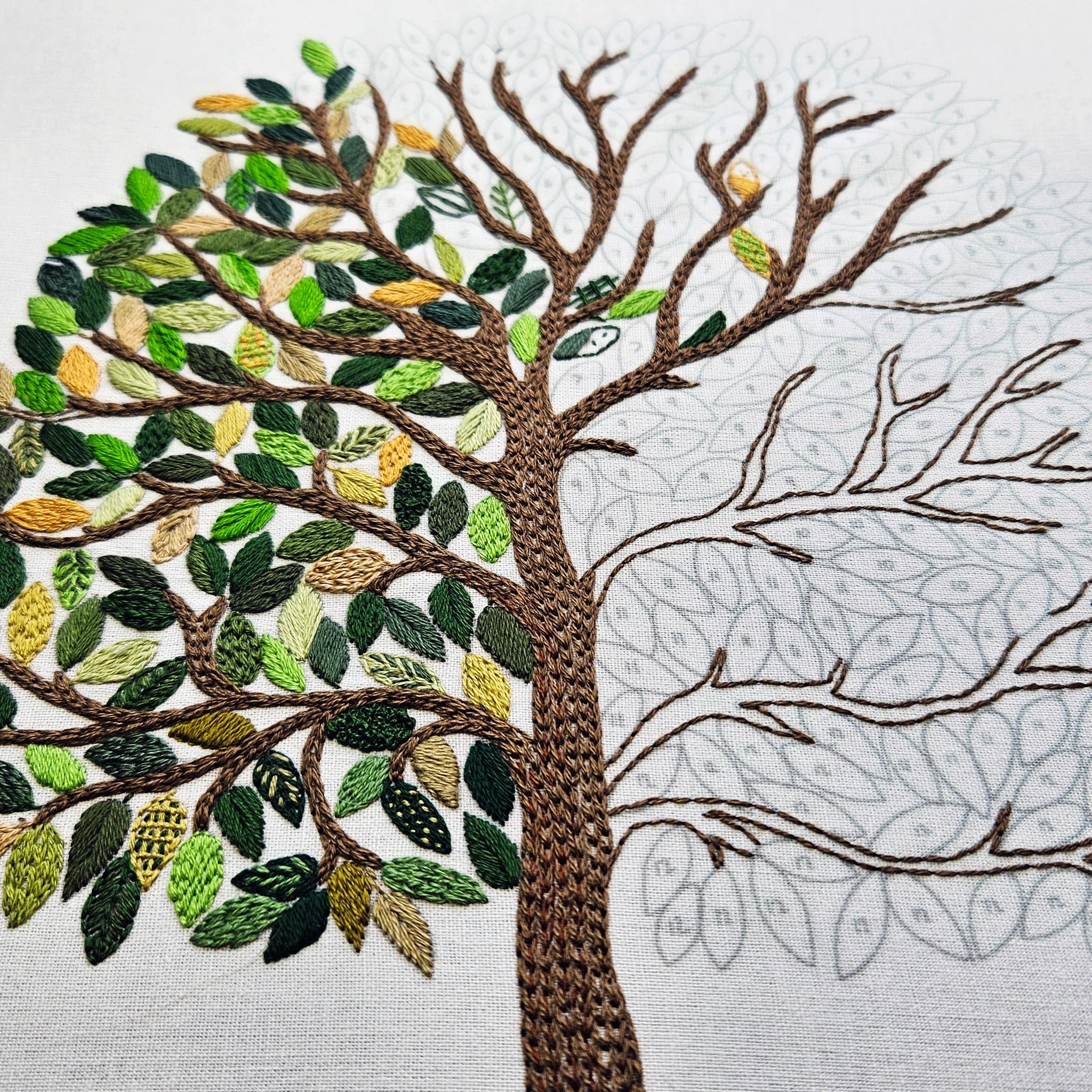 Embroidered tree with green leaves on a white background