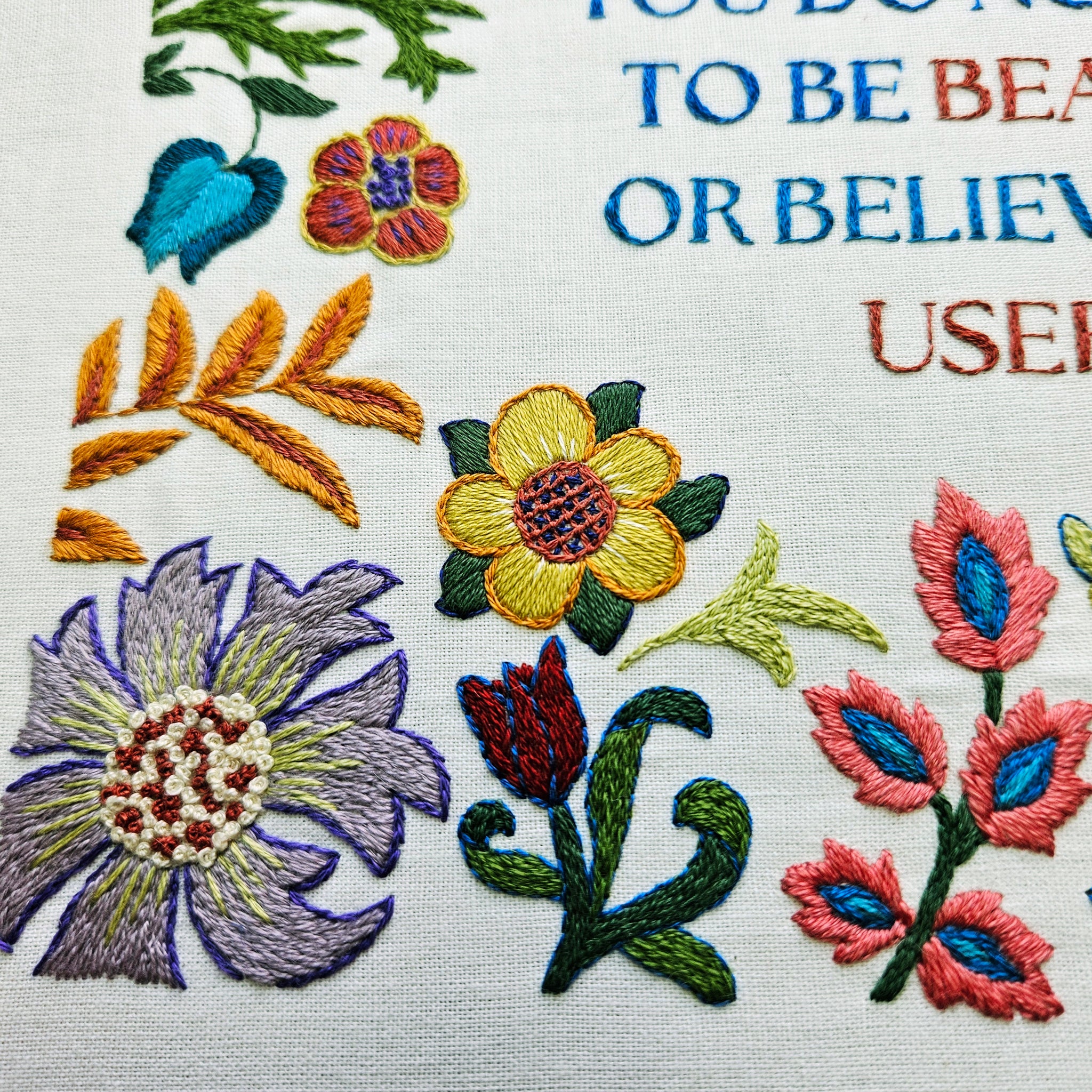 Embroidered flowers with text on a white background