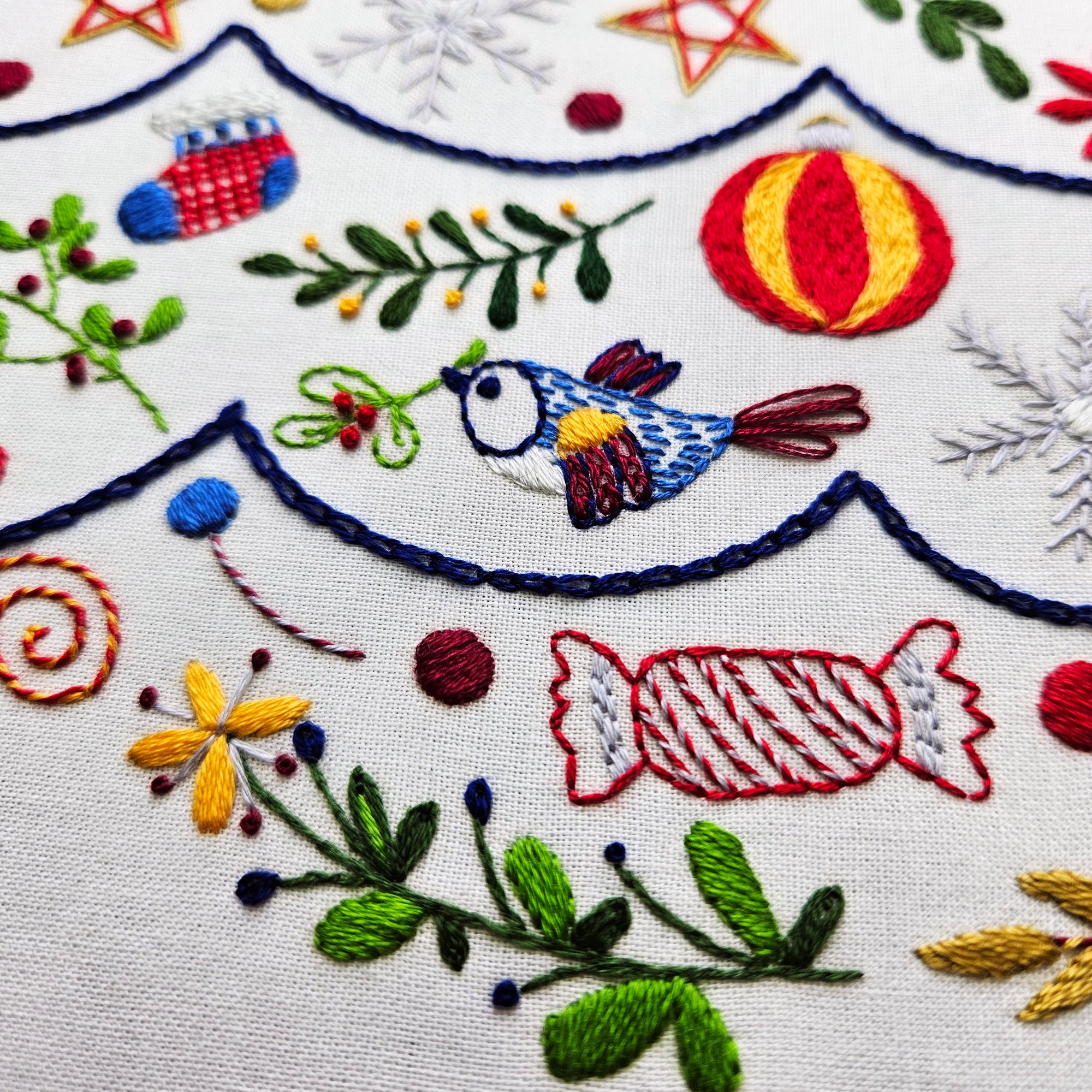 Embroidered design with colorful birds, flowers, and candy on a white background