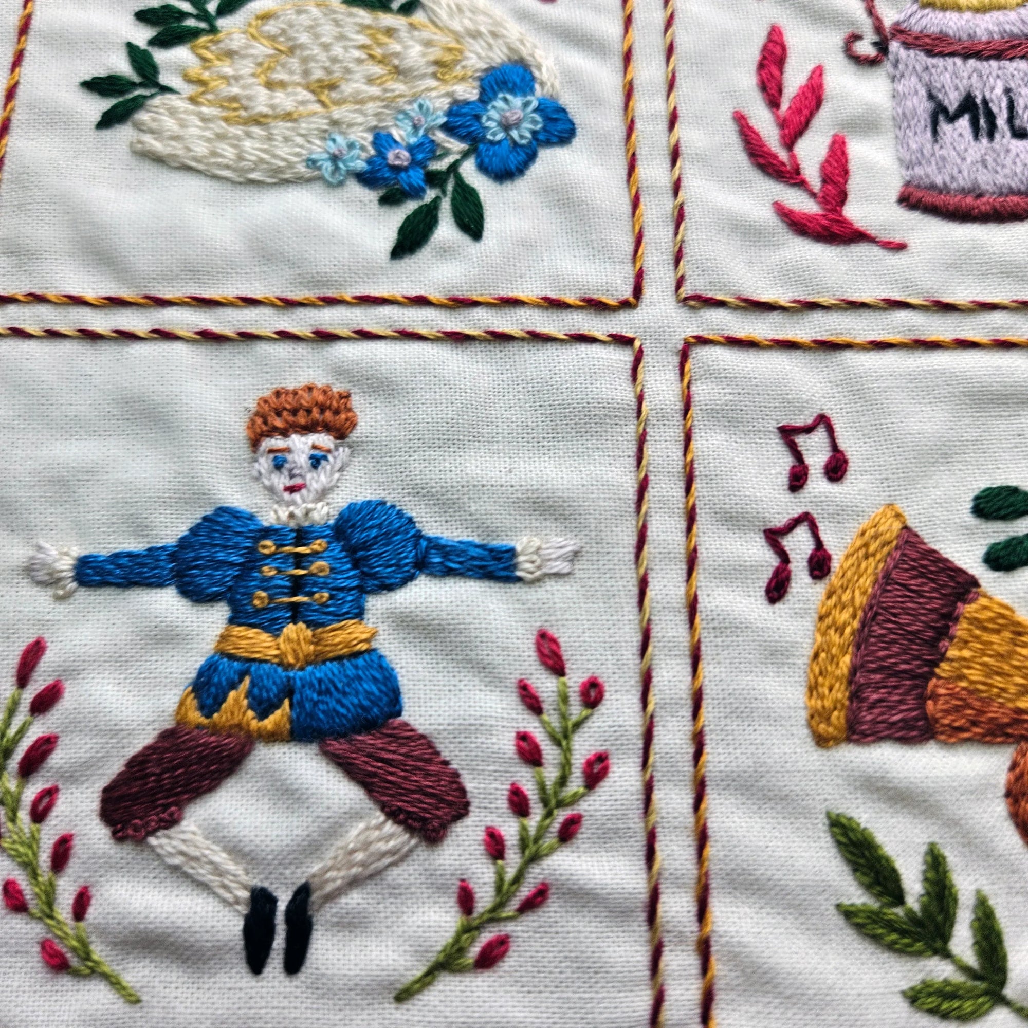 Embroidered fabric with a dancer, flowers, and other decorative elements.