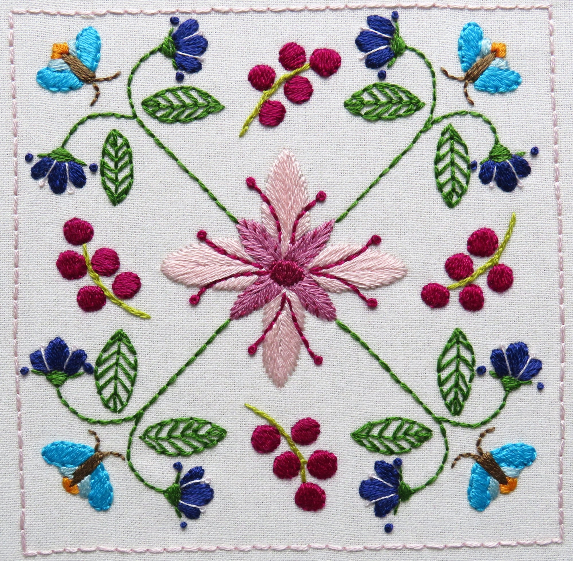 Embroidered design with flowers, leaves, and butterflies on a white background