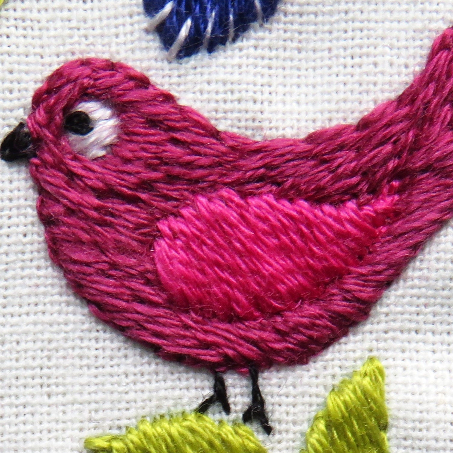 Embroidered pink bird on a white background