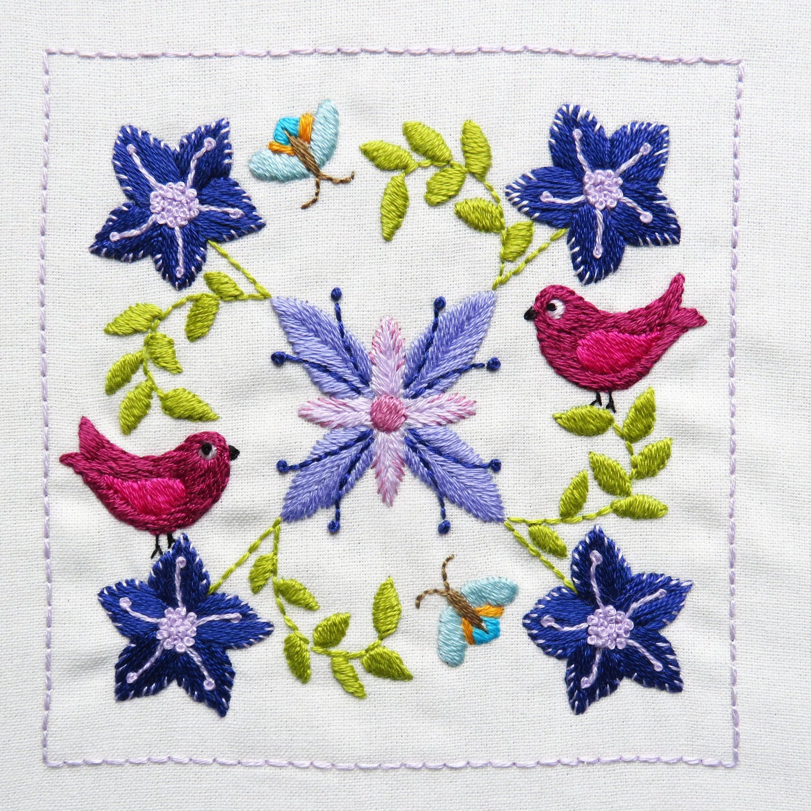Embroidered design with flowers and birds on a white background