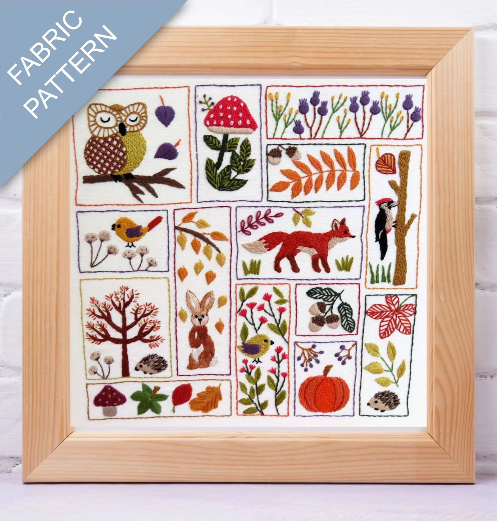 Framed fabric pattern with embroidered animals, plants, and nature-themed designs.