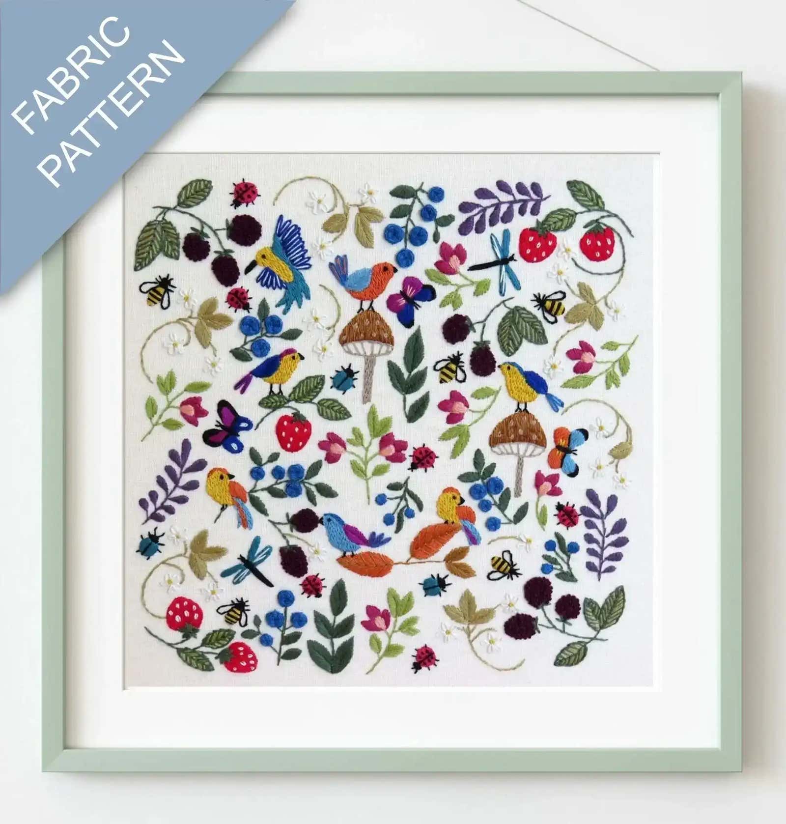 Framed fabric pattern with colorful birds, flowers, and leaves on a white background