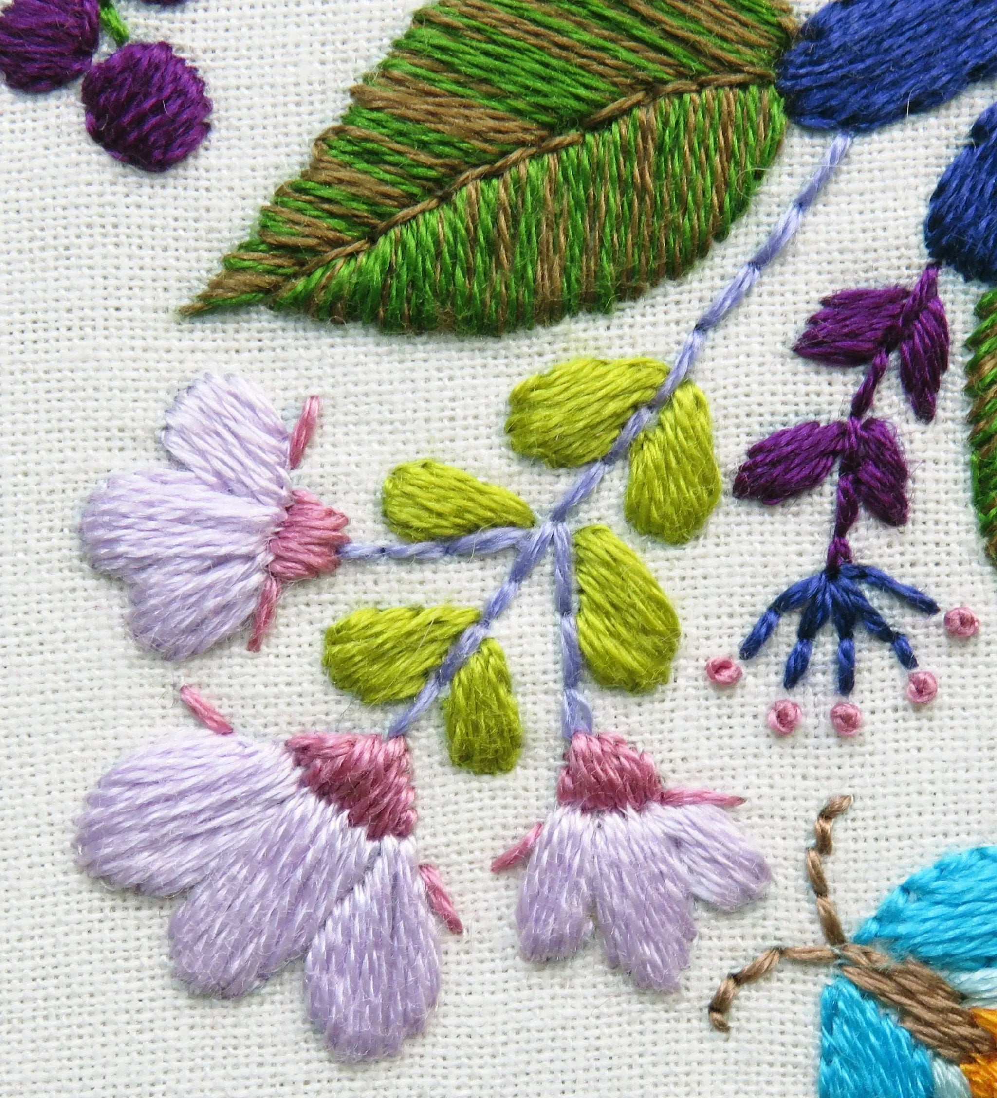 Close-up of embroidered flowers and leaves on fabric