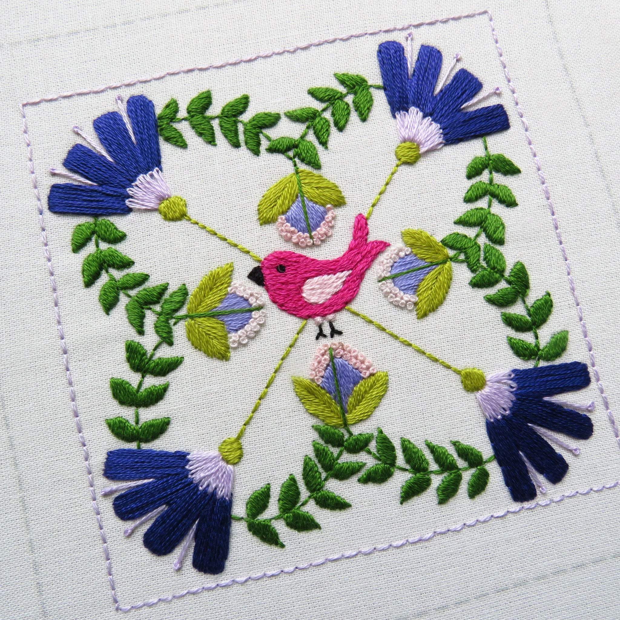 Embroidered design with a bird and flowers on a white background