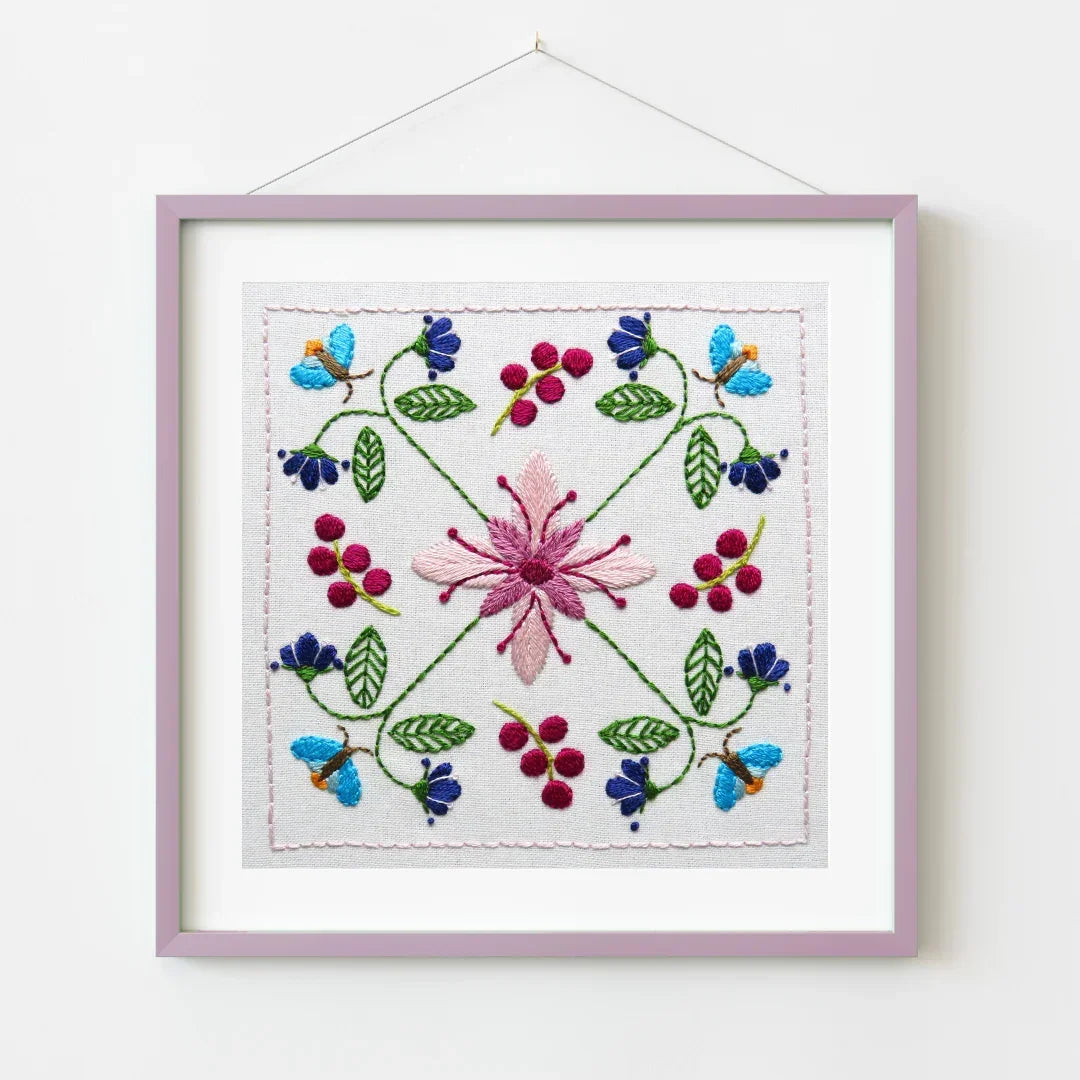 Embroidered floral design in a frame on a white background