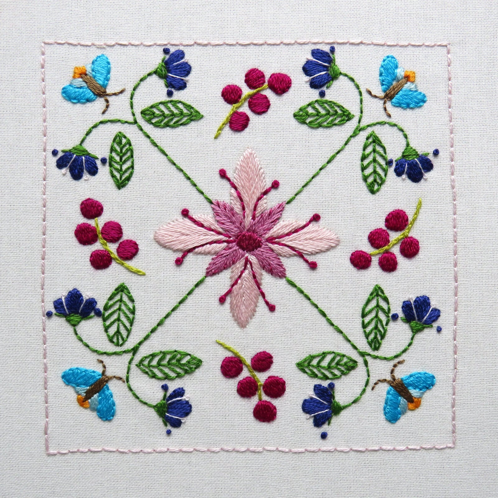 Embroidered design of flowers and butterflies on a white background