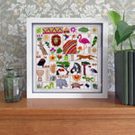 Framed artwork with colorful animal illustrations on a wooden surface with decorative background