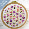 Embroidery hoop with floral and bee pattern on a marble surface
