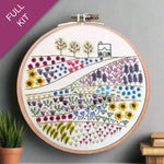 Embroidery hoop with floral design on a gray background