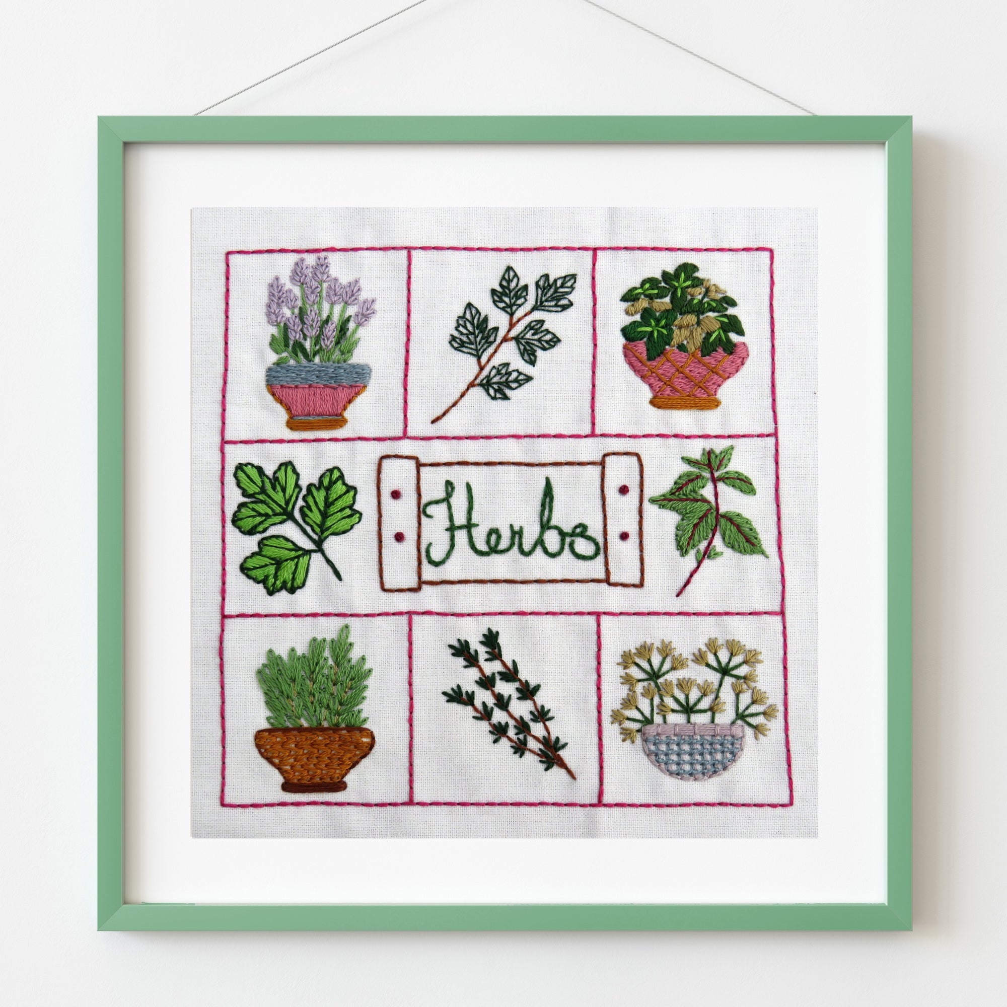 Embroidered panel with illustrations of herbs in pots on a white background