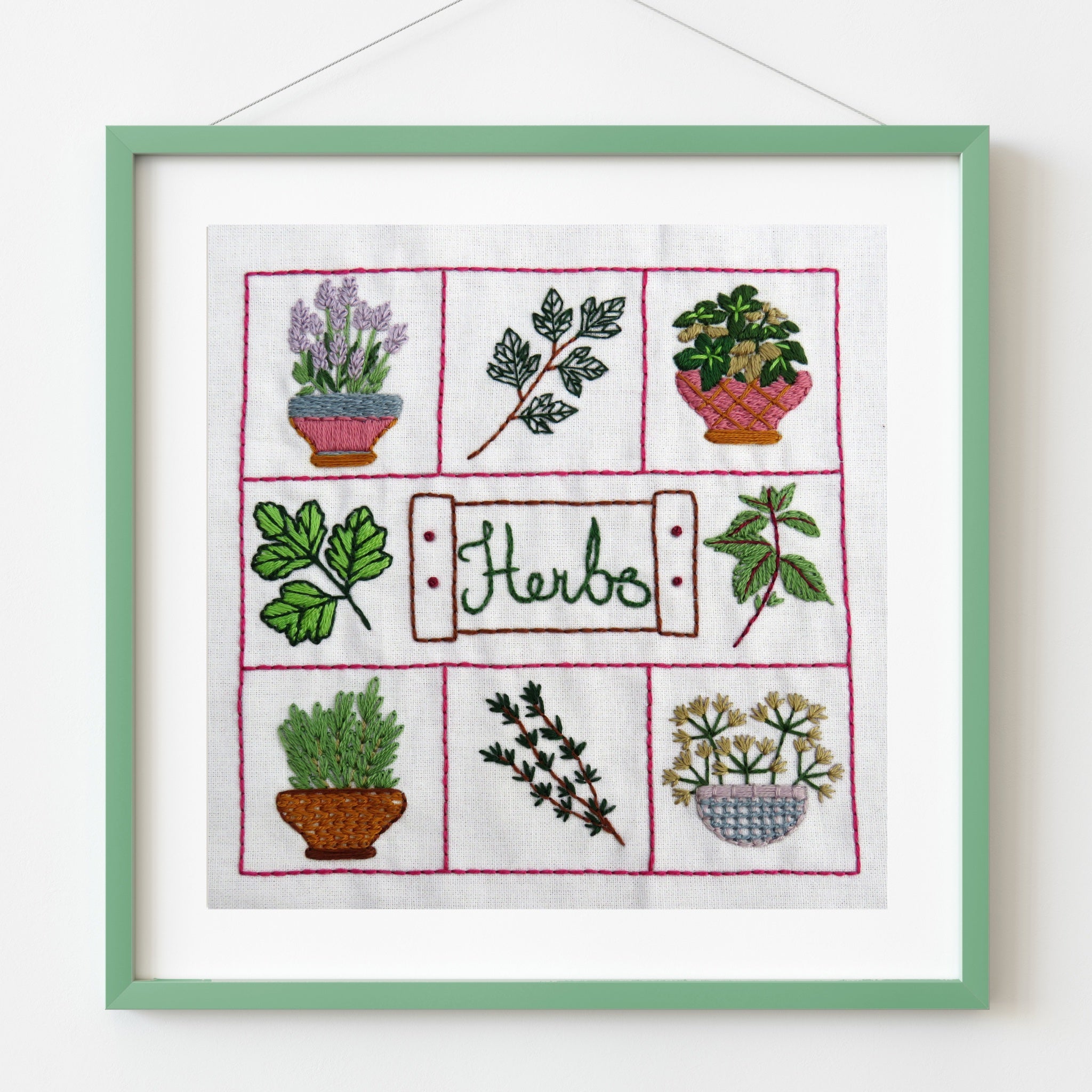 Embroidered panel with illustrations of herbs in pots on a white background