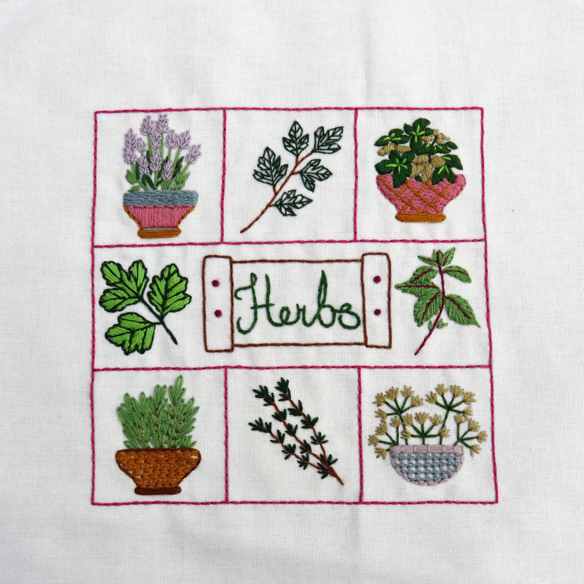 Embroidered design of herbs on a white fabric background