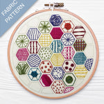 Embroidery hoop with colorful geometric pattern on a white background