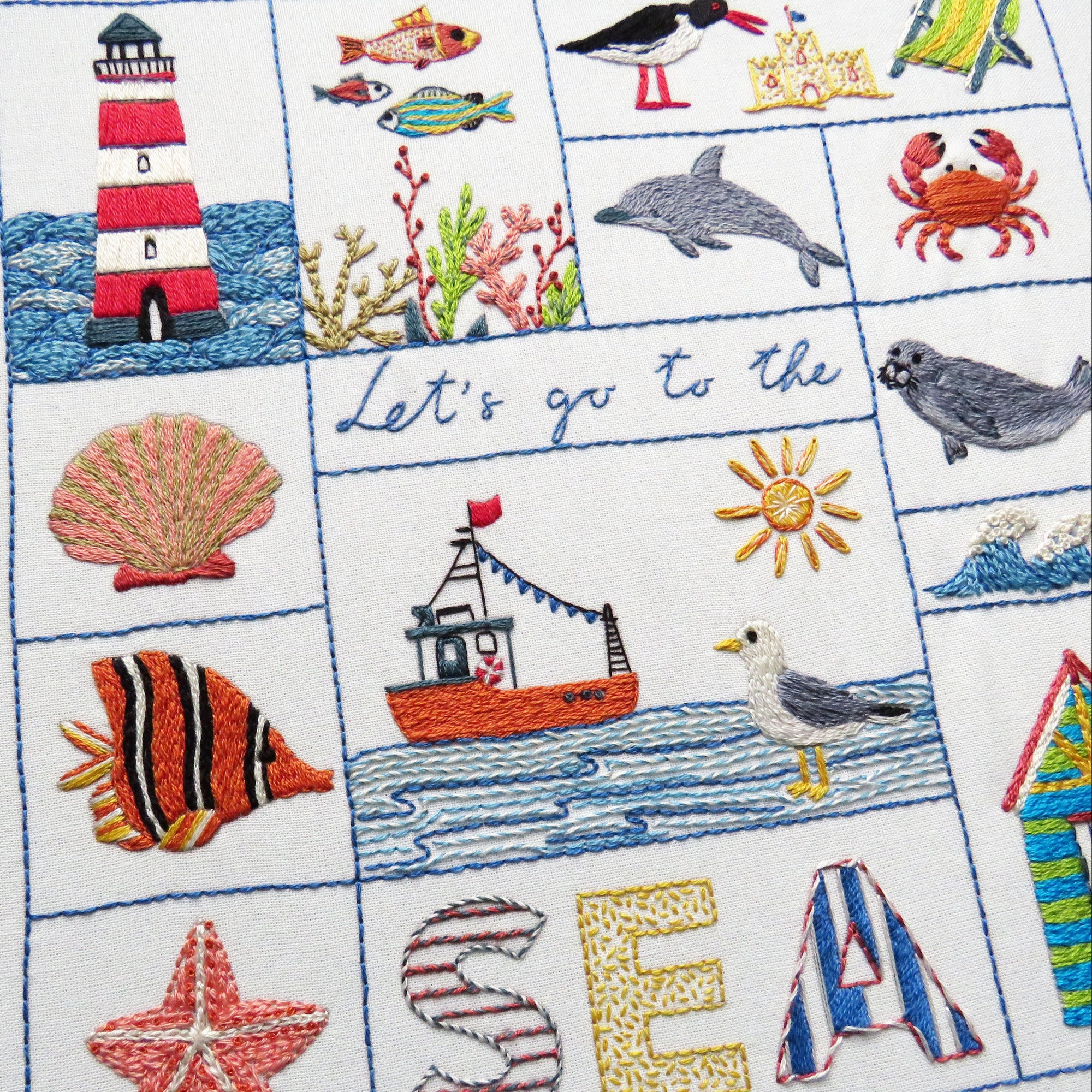 Embroidered panel with sea-themed designs including a lighthouse, fish, and seagull.
