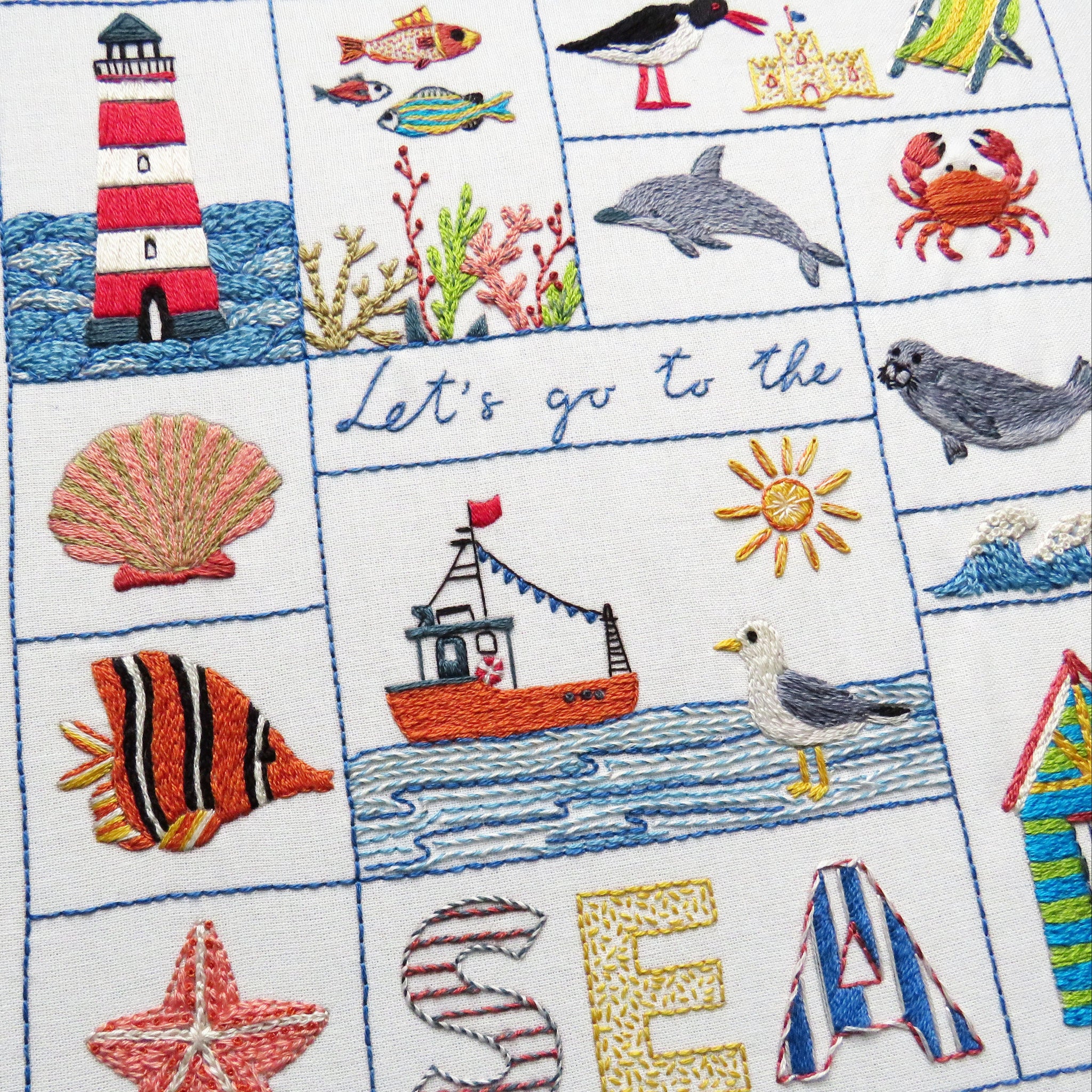 Embroidered panel with sea-themed designs including a lighthouse, fish, and seagull.