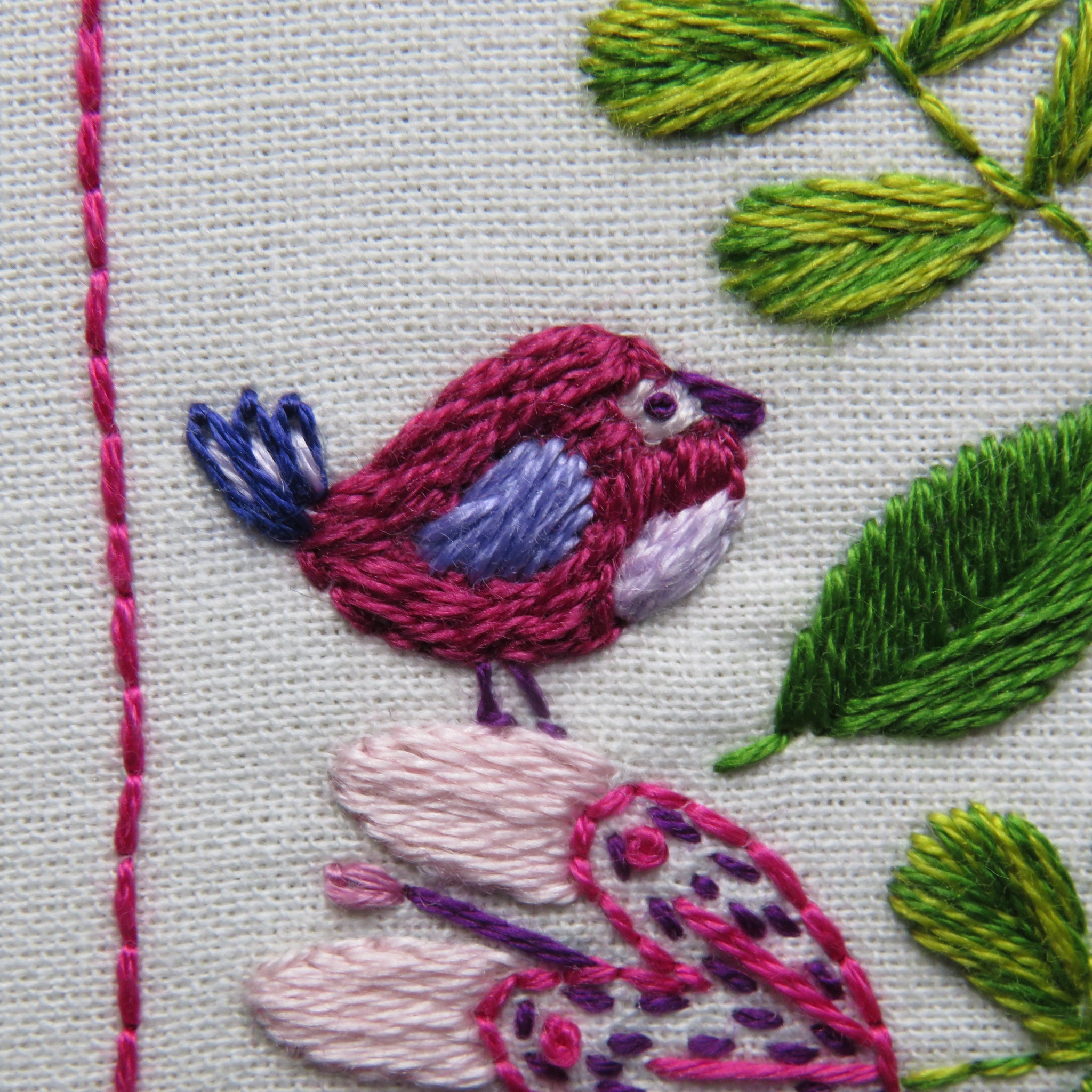 Embroidery of a bird and leaves on fabric