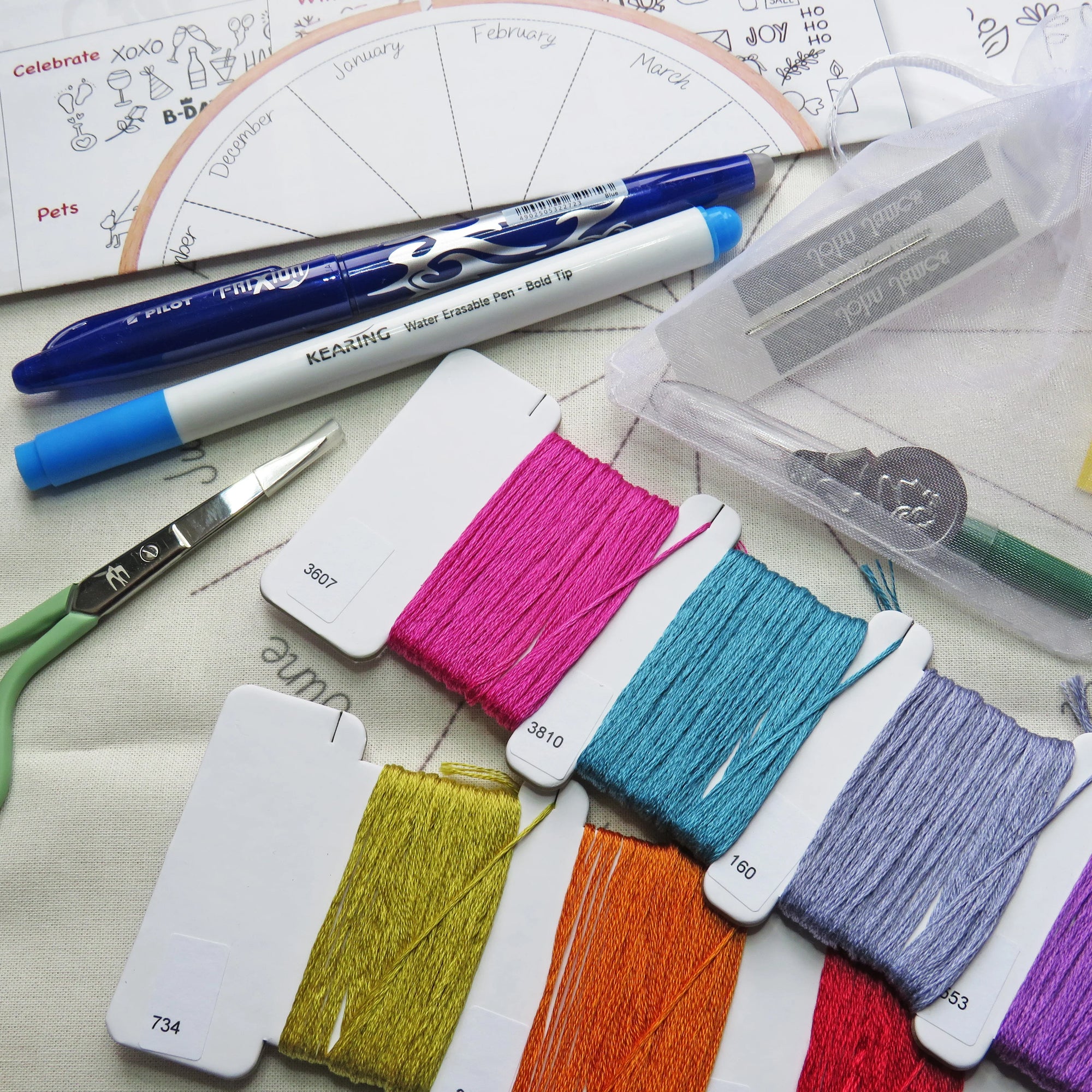 Color swatches with embroidery threads and markers on a textured surface