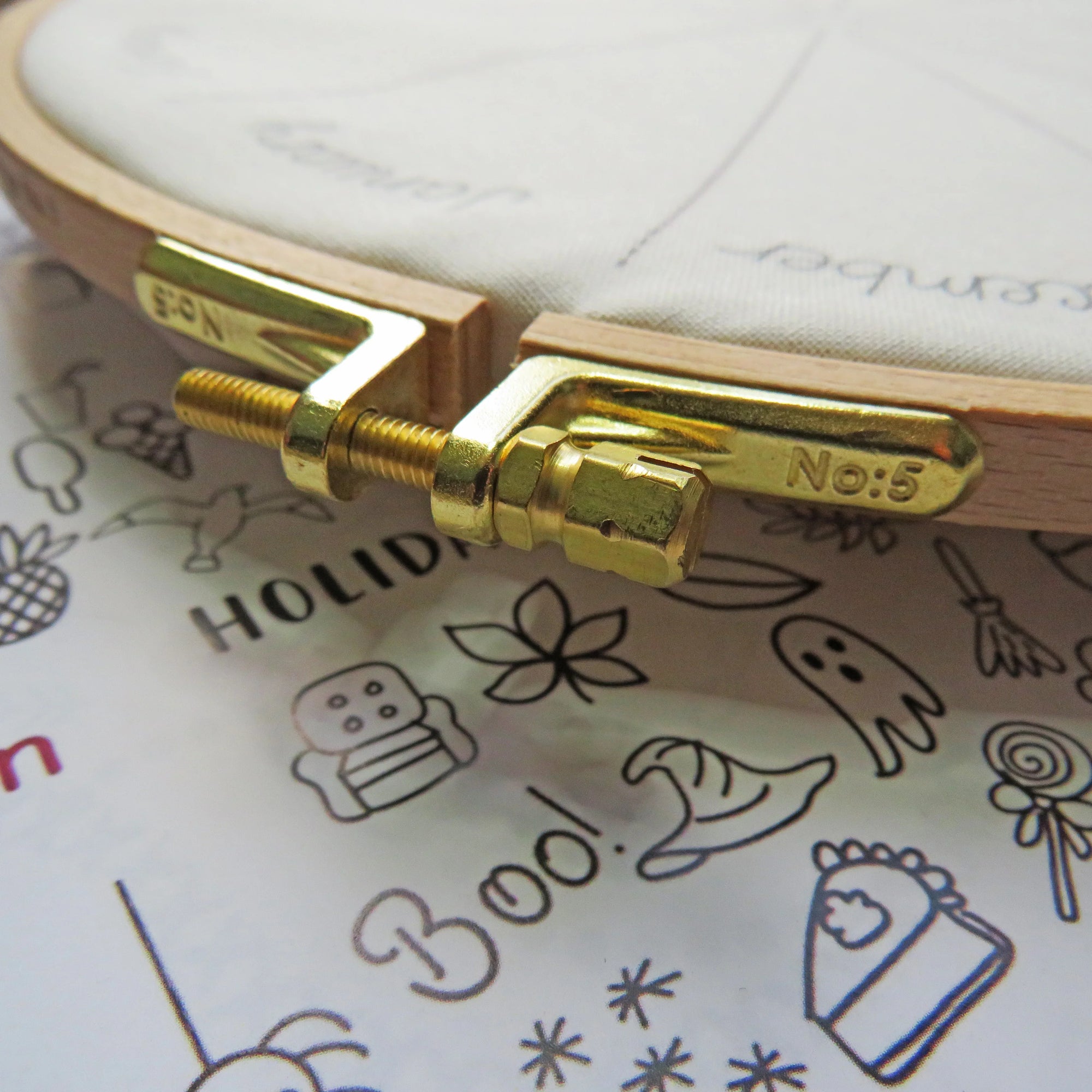 Gold-colored tool on a piece of paper with drawings and text