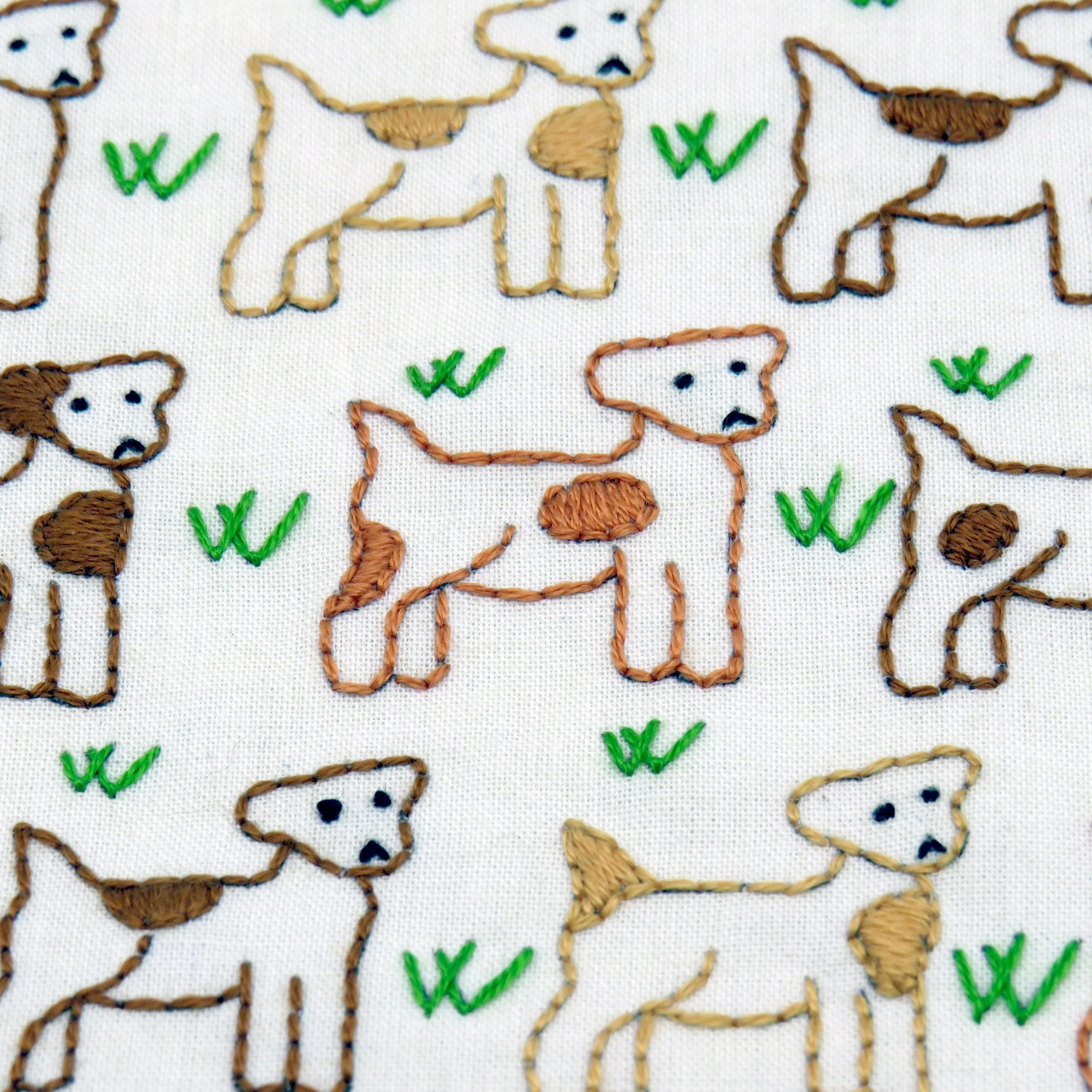 Pattern of embroidered deer with green leaves on a white background