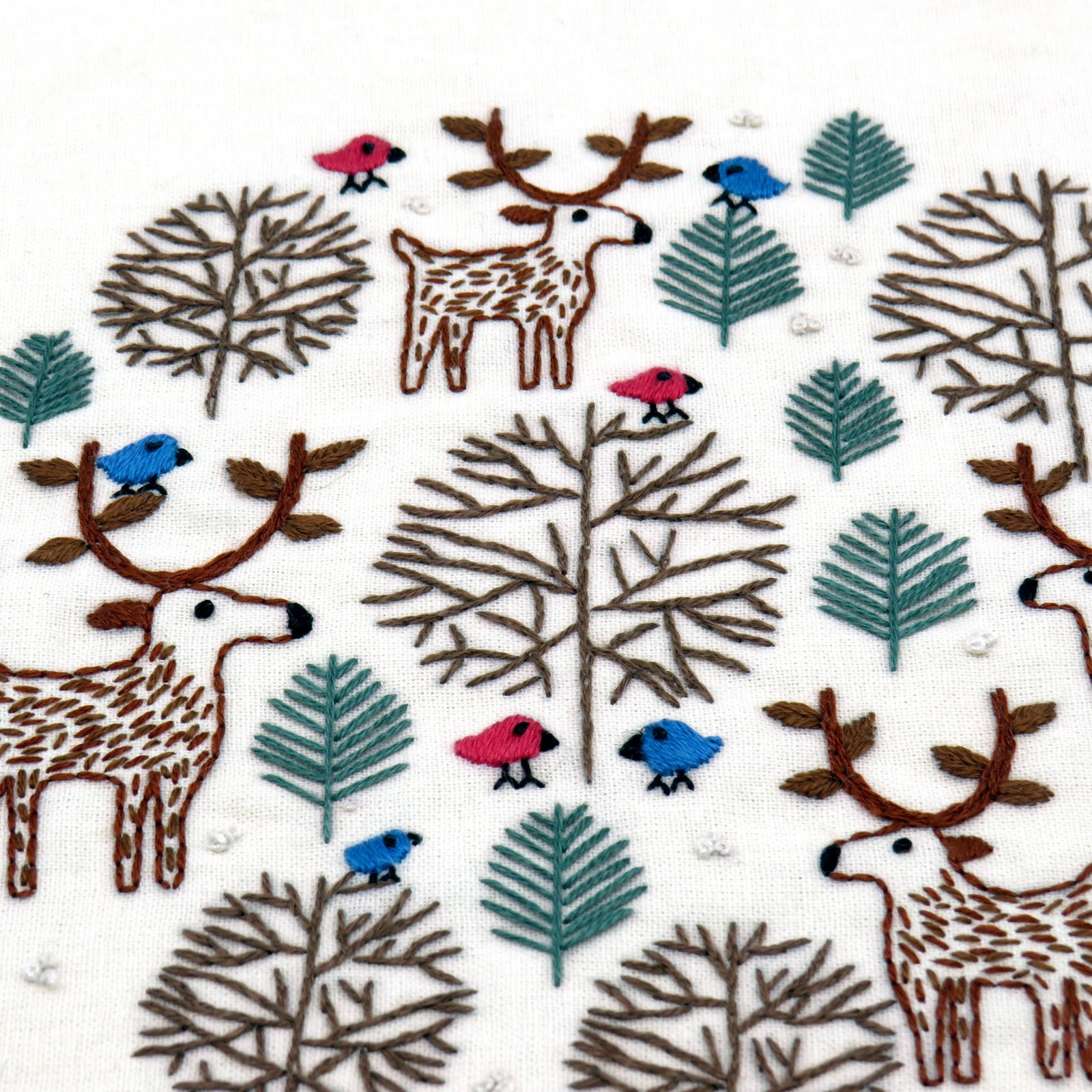 Pattern of deer, trees, and birds on a white background
