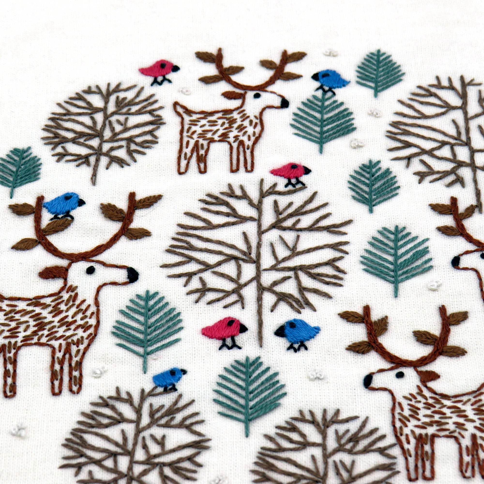 Pattern of deer, trees, and birds on a white background